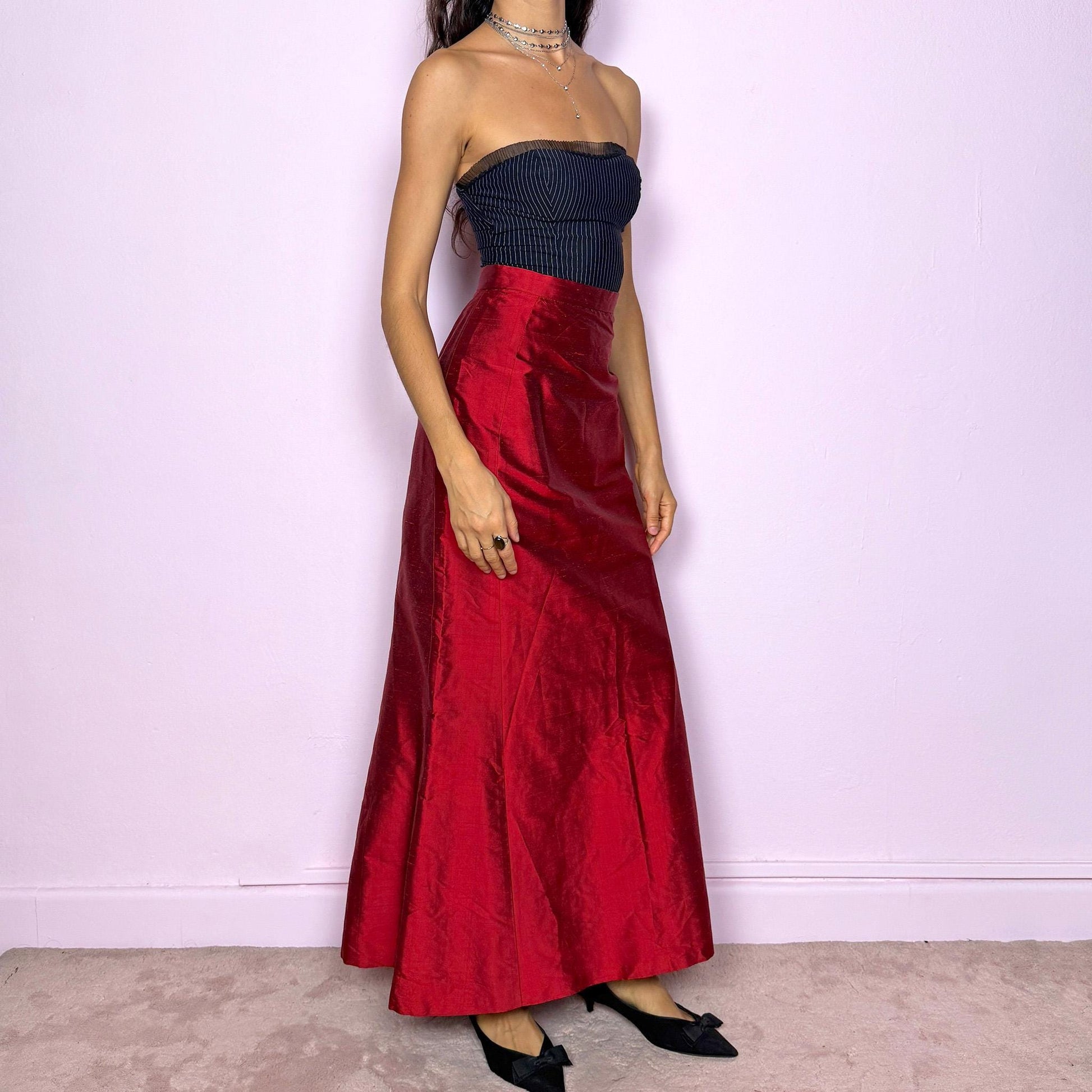 This vintage 90s red shiny maxi skirt features a sculpted mermaid silhouette with a high-waisted fit and back zipper closure. Made in France from non-stretch polyester, it radiates diva allure with a formal, romantic tone, perfect for gala nights, prom, or elegant evening events. A stunning statement piece of timeless sophistication. Made from non-stretch polyester. Great vintage condition.