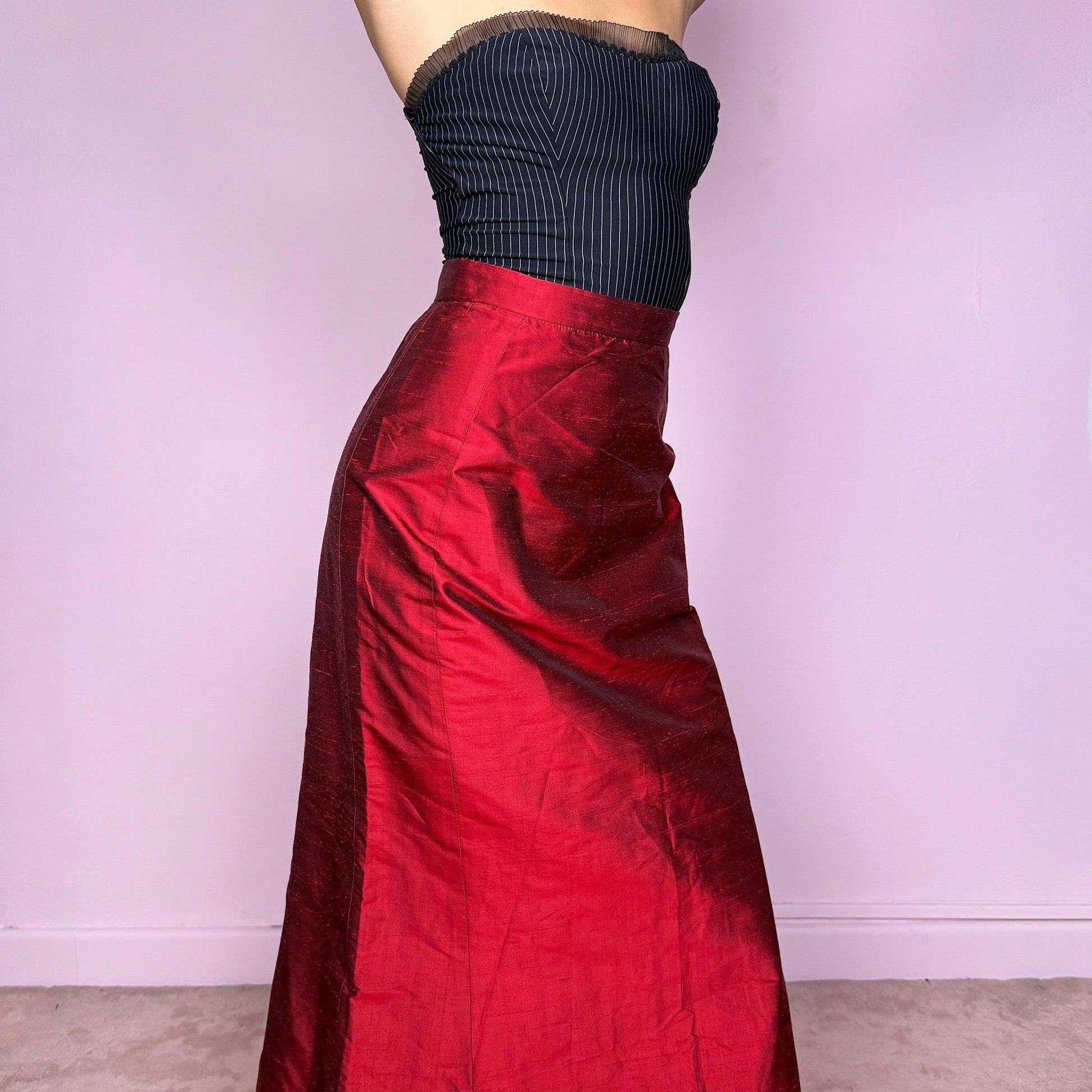 This vintage 90s red shiny maxi skirt features a sculpted mermaid silhouette with a high-waisted fit and back zipper closure. Made in France from non-stretch polyester, it radiates diva allure with a formal, romantic tone, perfect for gala nights, prom, or elegant evening events. A stunning statement piece of timeless sophistication. Made from non-stretch polyester. Great vintage condition.