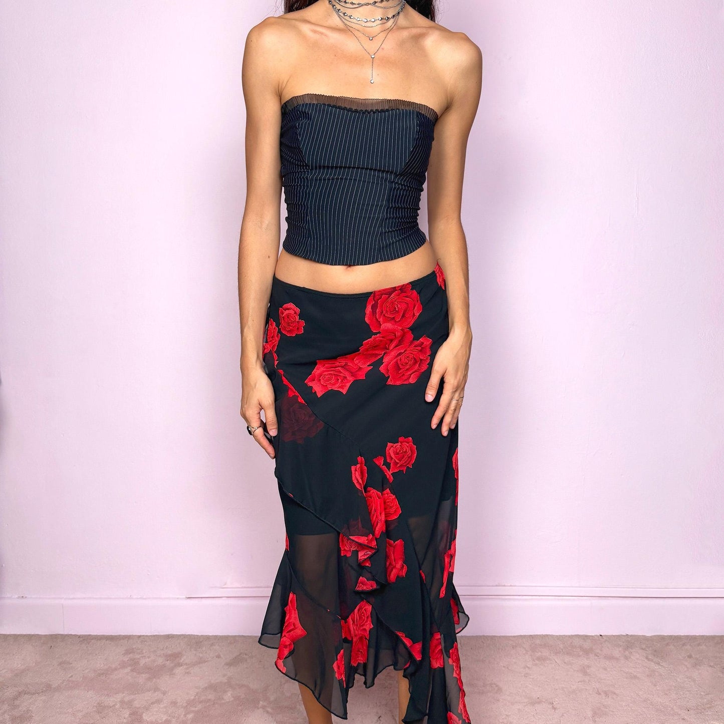 This vintage 90s black midi skirt features bold red rose floral prints, cascading ruffles, and a soft elastic waist for comfort and movement. Its romantic coquette design blends elegance and sensuality, perfect for formal events, summer nights, or evening parties. Can be worn low- or mid-rise for size L. Great vintage condition.