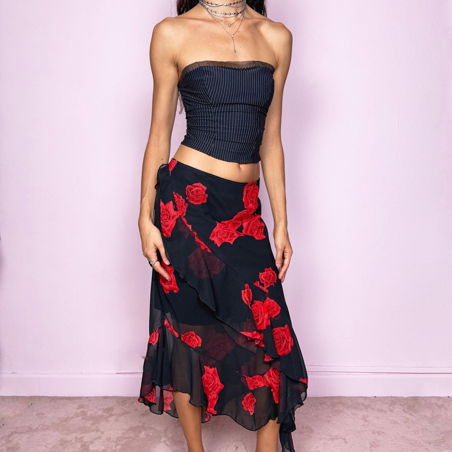 This vintage 90s black midi skirt features bold red rose floral prints, cascading ruffles, and a soft elastic waist for comfort and movement. Its romantic coquette design blends elegance and sensuality, perfect for formal events, summer nights, or evening parties. Can be worn low- or mid-rise for size L. Great vintage condition.