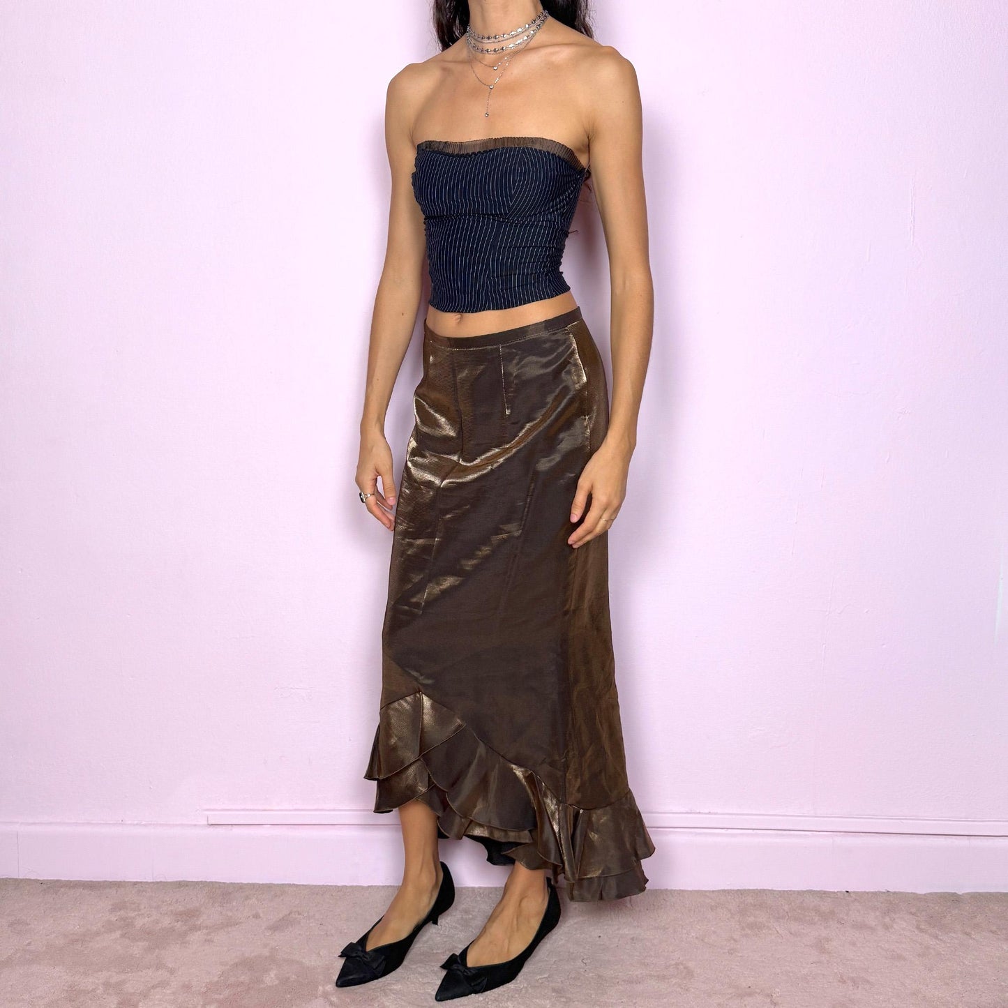 This vintage 90s shiny iridescent golden khaki-brown midi skirt features a ruffled tulip hem and a back zipper closure. Made in Spain, it shimmers beautifully under light, perfect for gala nights, prom, or elegant formal events. Fits mid-rise in size S or low-rise in XS. Made from a non-stretch rayon polyester blend. Great vintage condition.