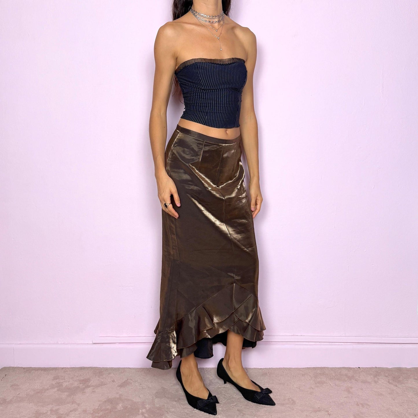 This vintage 90s shiny iridescent golden khaki-brown midi skirt features a ruffled tulip hem and a back zipper closure. Made in Spain, it shimmers beautifully under light, perfect for gala nights, prom, or elegant formal events. Fits mid-rise in size S or low-rise in XS. Made from a non-stretch rayon polyester blend. Great vintage condition.