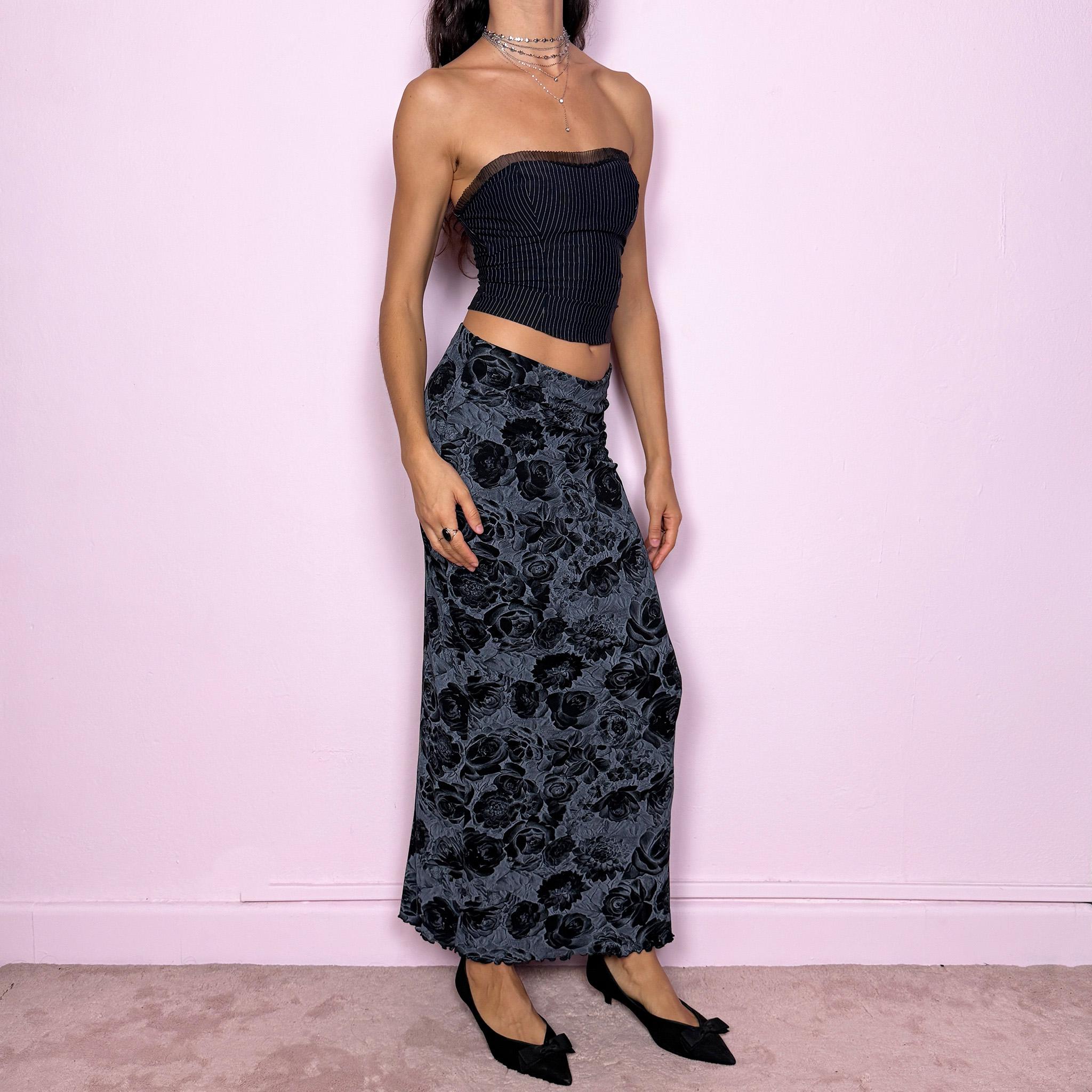 This vintage 2000s black and gray floral rose print midi skirt features a soft elastic waist and a slightly body-hugging silhouette. Made in Europe from a polyamide blend, it channels whimsigoth and 90s grunge-inspired elegance, perfect for everyday wear or dark romantic styling. Fits mid- to low-rise for size S. Excellent vintage condition.