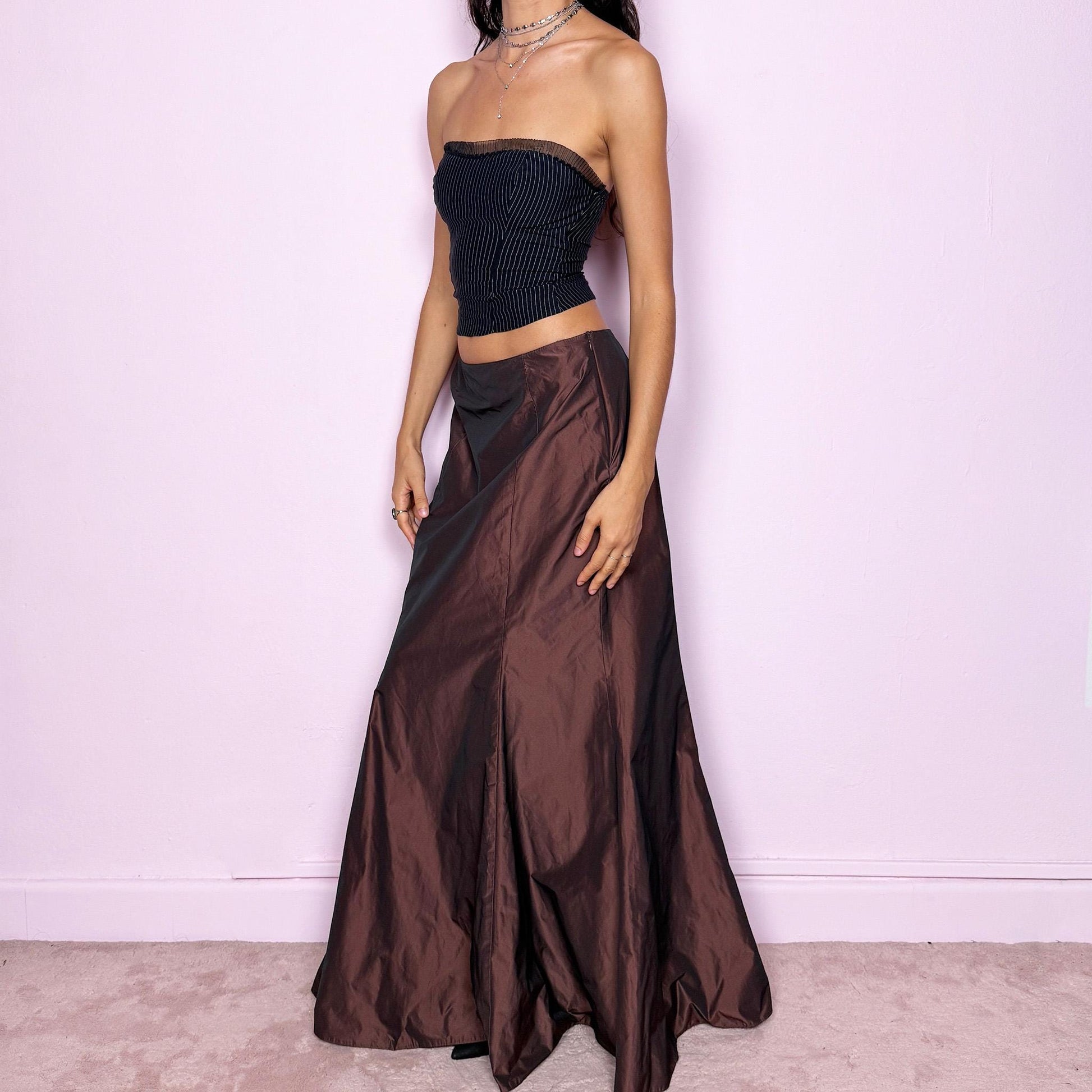 This vintage 90s brown satin-style iridescent maxi skirt features a dramatic mermaid silhouette with a side zipper closure. Crafted from structured non-stretch fabric, it shimmers beautifully under light, creating a darkly romantic and whimsical look. Perfect for galas, prom, or formal night events. Fits high-waisted for size M. Excellent vintage condition.