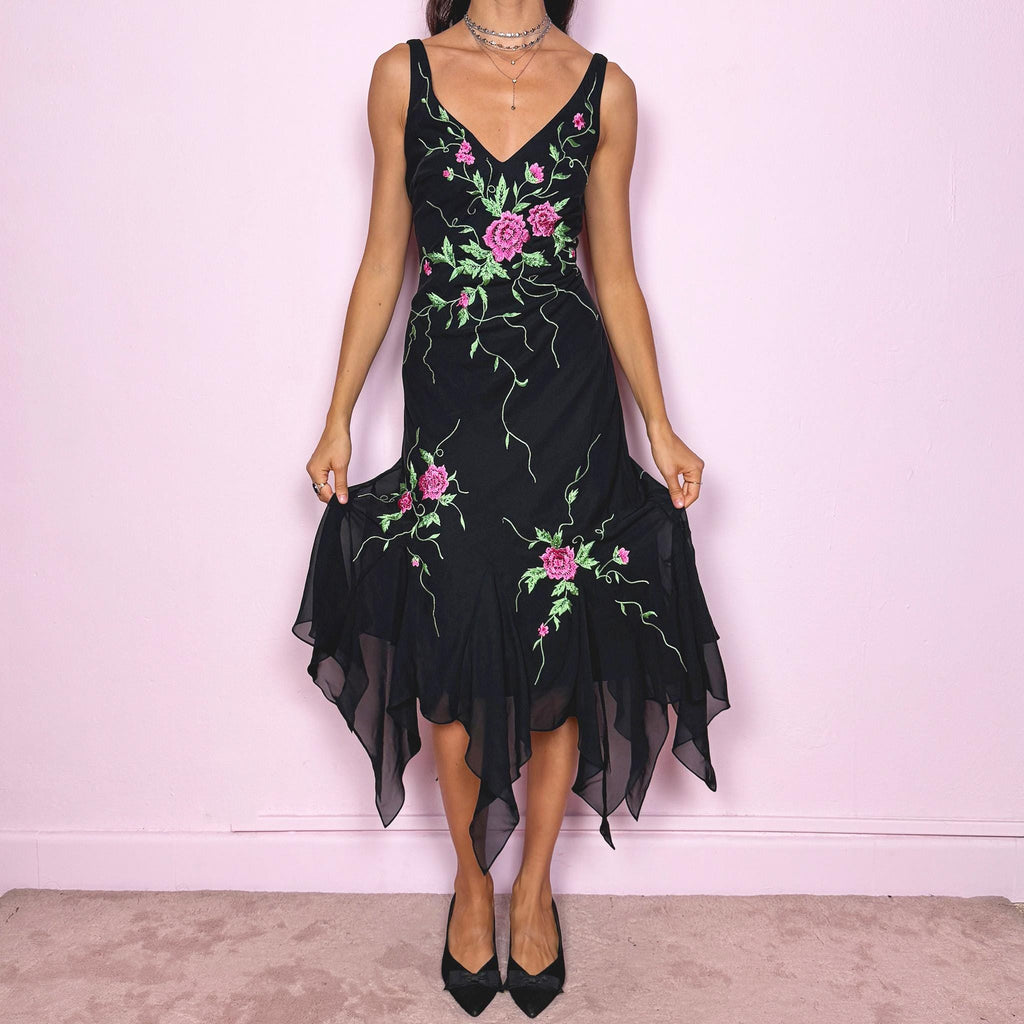 Stunning vintage 2000s black sleeveless V-neck long midi dress featuring pink and green floral embroidered details with beaded accents. The asymmetric handkerchief-style hem adds movement and a romantic statement look, perfect for gala events, formal parties or night occasions. Made from polyester. Excellent vintage condition.
