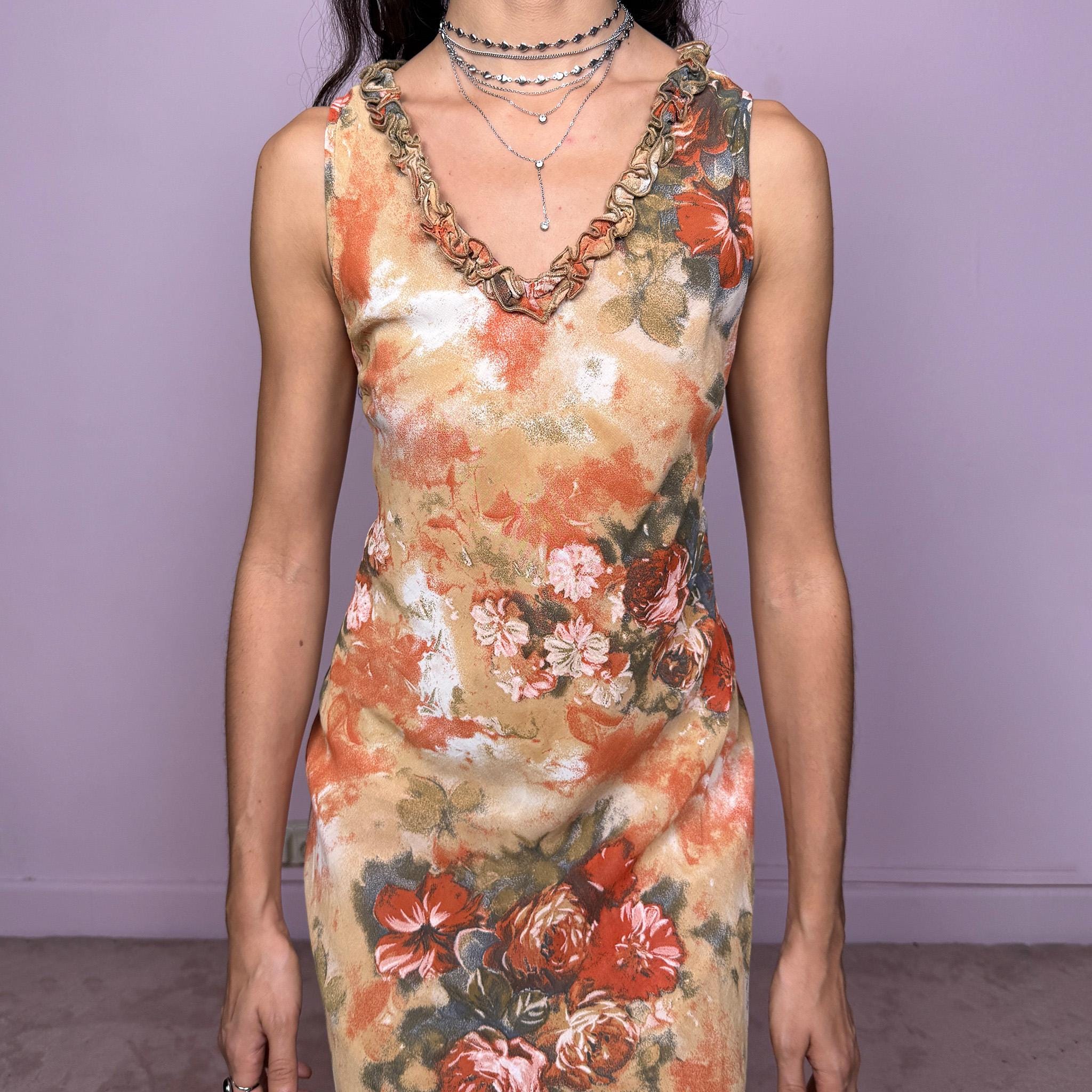 Vintage 90s beige, orange and green floral print sleeveless midi dress featuring a ruffle V-neckline and an asymmetric ruffle hem. The fabric drapes beautifully, creating a romantic and feminine silhouette ideal for spring or summer events. Versatile enough for casual daytime outings or more formal occasions, with pastel tones that give it an art-inspired, delicate feel. Made from polyester. Excellent vintage condition.