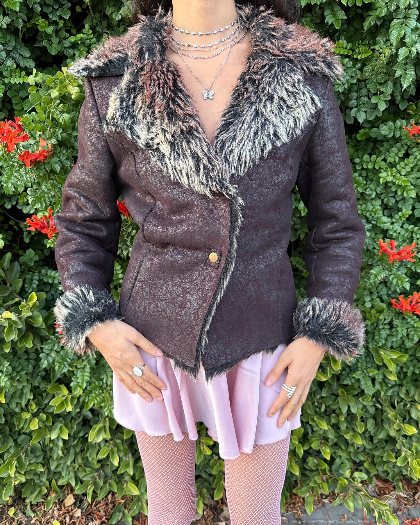 Stunning vintage 2000s dark brown–burgundy Penny Lane–style jacket featuring a distressed faux-leather exterior with full beige–brown–black faux-fur lining. Designed with a dramatic faux-fur trimmed collar and cuffs, shaped seams for a fitted silhouette and a two snap-button closure. The polyester-blend fabric has no stretch and delivers a warm, cozy feel perfect for winter layering. A French-design cyber streetwear and grunge statement coat ideal for night outings and bold Y2K styling.