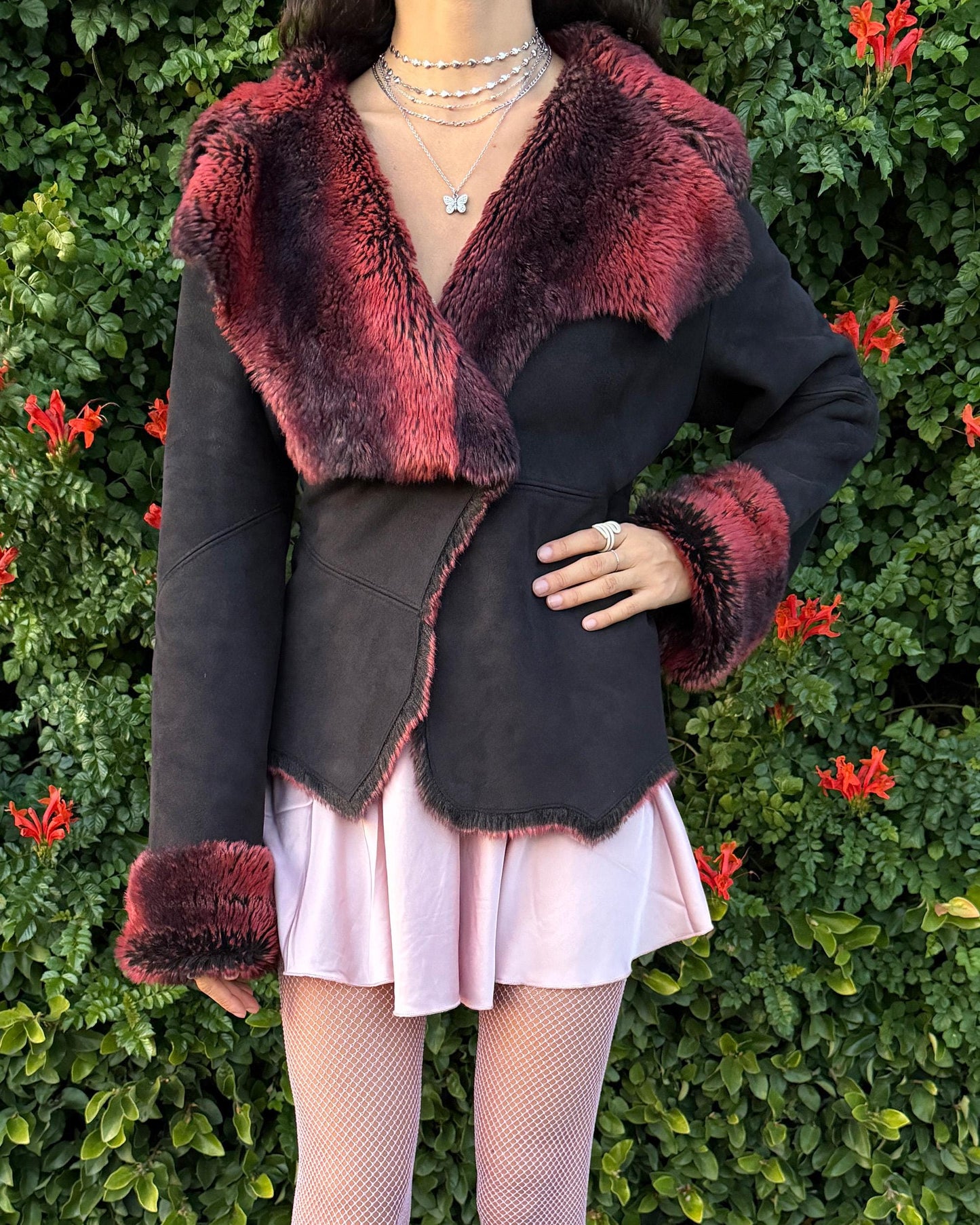 Stunning vintage 2000s Penny Lane–style jacket featuring a black faux-suede exterior with full red-and-black faux-fur lining. Designed with a dramatic faux-fur trimmed collar and cuffs, angled panel construction and a single button closure for a fitted silhouette. The polyester–acrylic blend has no stretch and provides a warm, cozy feel ideal for winter layering. A French-design cyber streetwear and grunge statement coat perfect for night outings and bold Y2K styling.