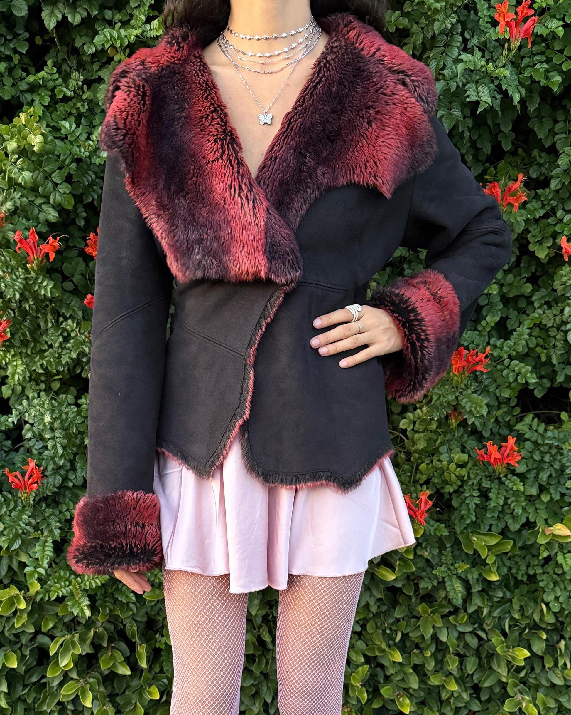 Stunning vintage 2000s Penny Lane–style jacket featuring a black faux-suede exterior with full red-and-black faux-fur lining. Designed with a dramatic faux-fur trimmed collar and cuffs, angled panel construction and a single button closure for a fitted silhouette. The polyester–acrylic blend has no stretch and provides a warm, cozy feel ideal for winter layering. A French-design cyber streetwear and grunge statement coat perfect for night outings and bold Y2K styling.