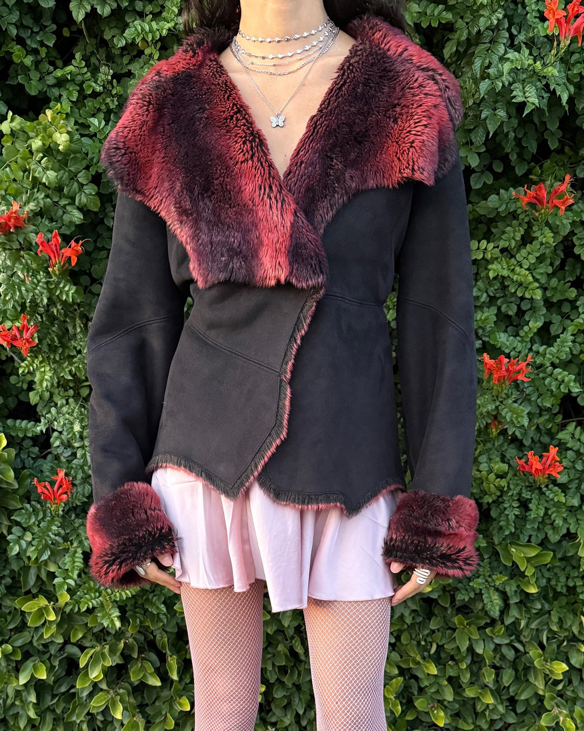 Stunning vintage 2000s Penny Lane–style jacket featuring a black faux-suede exterior with full red-and-black faux-fur lining. Designed with a dramatic faux-fur trimmed collar and cuffs, angled panel construction and a single button closure for a fitted silhouette. The polyester–acrylic blend has no stretch and provides a warm, cozy feel ideal for winter layering. A French-design cyber streetwear and grunge statement coat perfect for night outings and bold Y2K styling.