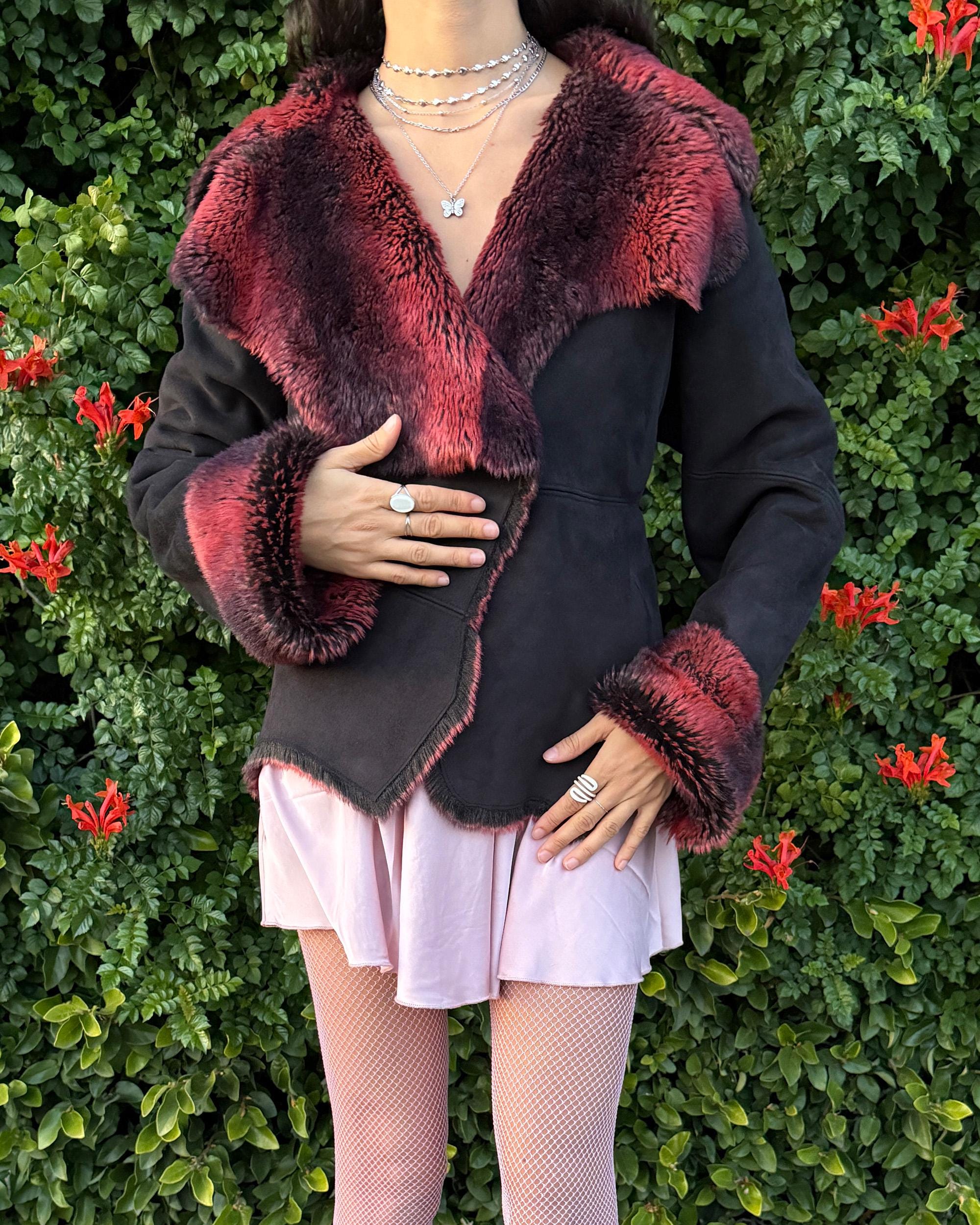 Stunning vintage 2000s Penny Lane–style jacket featuring a black faux-suede exterior with full red-and-black faux-fur lining. Designed with a dramatic faux-fur trimmed collar and cuffs, angled panel construction and a single button closure for a fitted silhouette. The polyester–acrylic blend has no stretch and provides a warm, cozy feel ideal for winter layering. A French-design cyber streetwear and grunge statement coat perfect for night outings and bold Y2K styling.