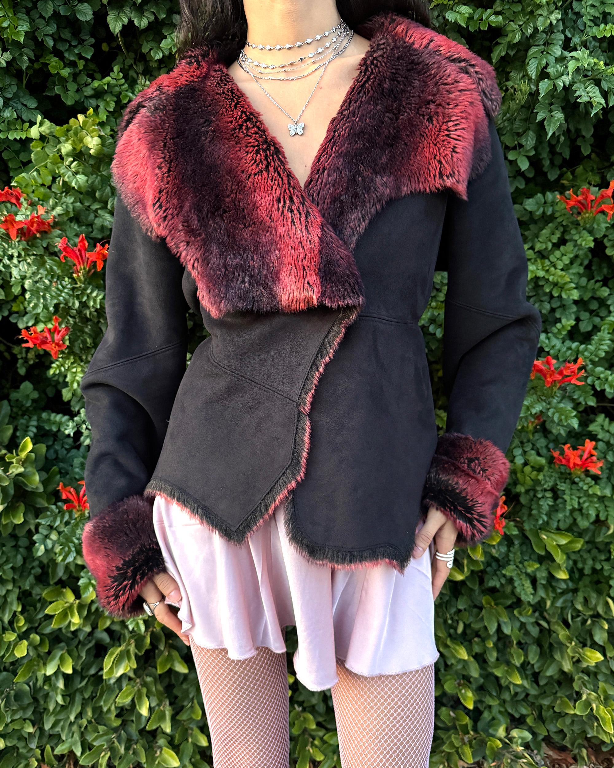 Stunning vintage 2000s Penny Lane–style jacket featuring a black faux-suede exterior with full red-and-black faux-fur lining. Designed with a dramatic faux-fur trimmed collar and cuffs, angled panel construction and a single button closure for a fitted silhouette. The polyester–acrylic blend has no stretch and provides a warm, cozy feel ideal for winter layering. A French-design cyber streetwear and grunge statement coat perfect for night outings and bold Y2K styling.