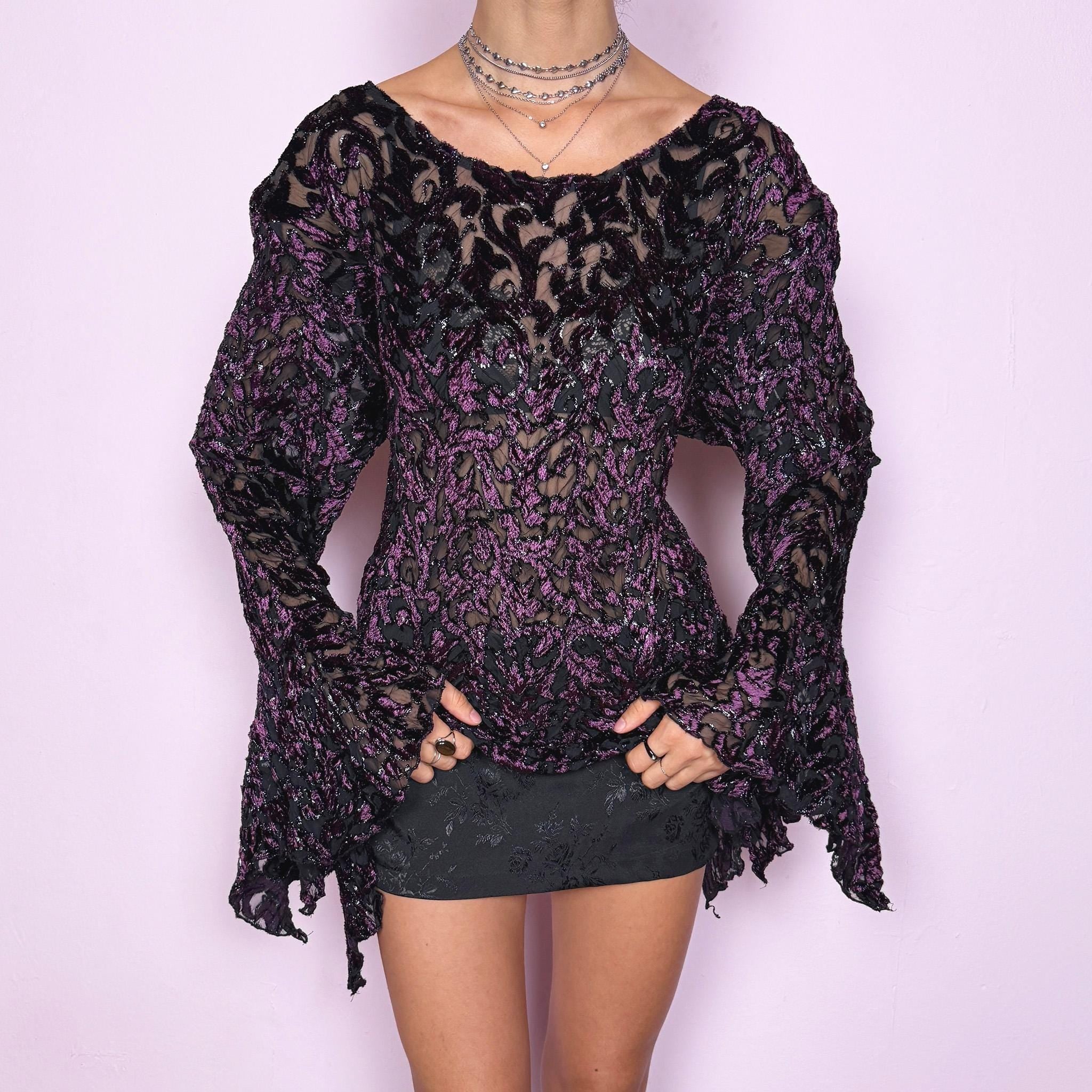 This vintage 2000s purple and black devoré velvet top delivers a dark romantic, witchy, goth aesthetic with a fitted bodice, sheer burnout pattern, metallic threads, asymmetric bell sleeves, and a flared hem. Ideal for evening styling, festivals, and statement layering. An archival French piece with a stretchy finish for comfortable wear. Excellent vintage condition.