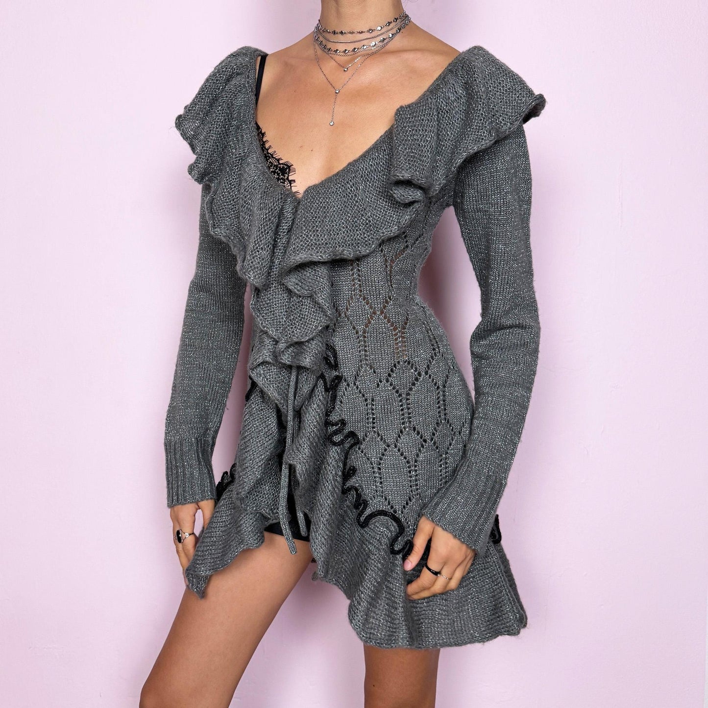 This romantic vintage 2000s gray longline open-knit cardigan features a dramatic ruffle neckline, ruffled hem, and a tie-front closure. The soft, draped silhouette and textured open-knit pattern create a whimsical coquette feel, ideal for autumn layering, winter fairycore styling, or cozy everyday outfits. Made from a stretchy acrylic and mohair blend. Great vintage condition.