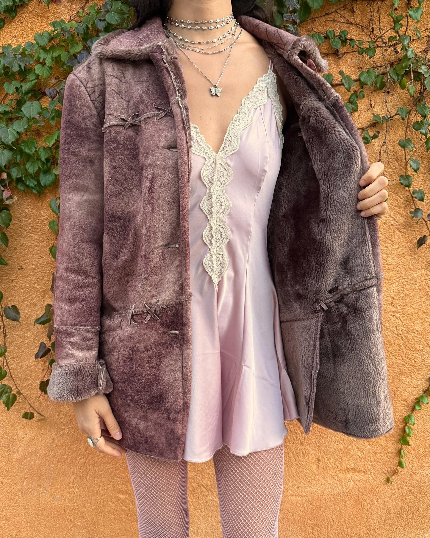 Vintage 2000s faux shearling coat in a rare reddish-brown (terracotta) tie-dye distressed finish. Features a faux fur collar and cuffs, button closure, side pockets, and decorative criss-cross stitch detailing for a dystopic cyber-grunge aesthetic. The straight silhouette makes it ideal for winter layering and festival styling. A standout 2000s piece for streetwear, weird-girl outfits, and bold cold-weather looks. Made from a polyester acrylic blend. Great vintage condition.