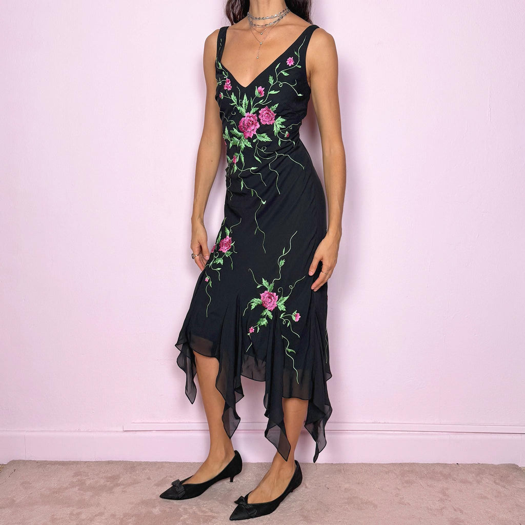 Stunning vintage 2000s black sleeveless V-neck long midi dress featuring pink and green floral embroidered details with beaded accents. The asymmetric handkerchief-style hem adds movement and a romantic statement look, perfect for gala events, formal parties or night occasions. Made from polyester. Excellent vintage condition.