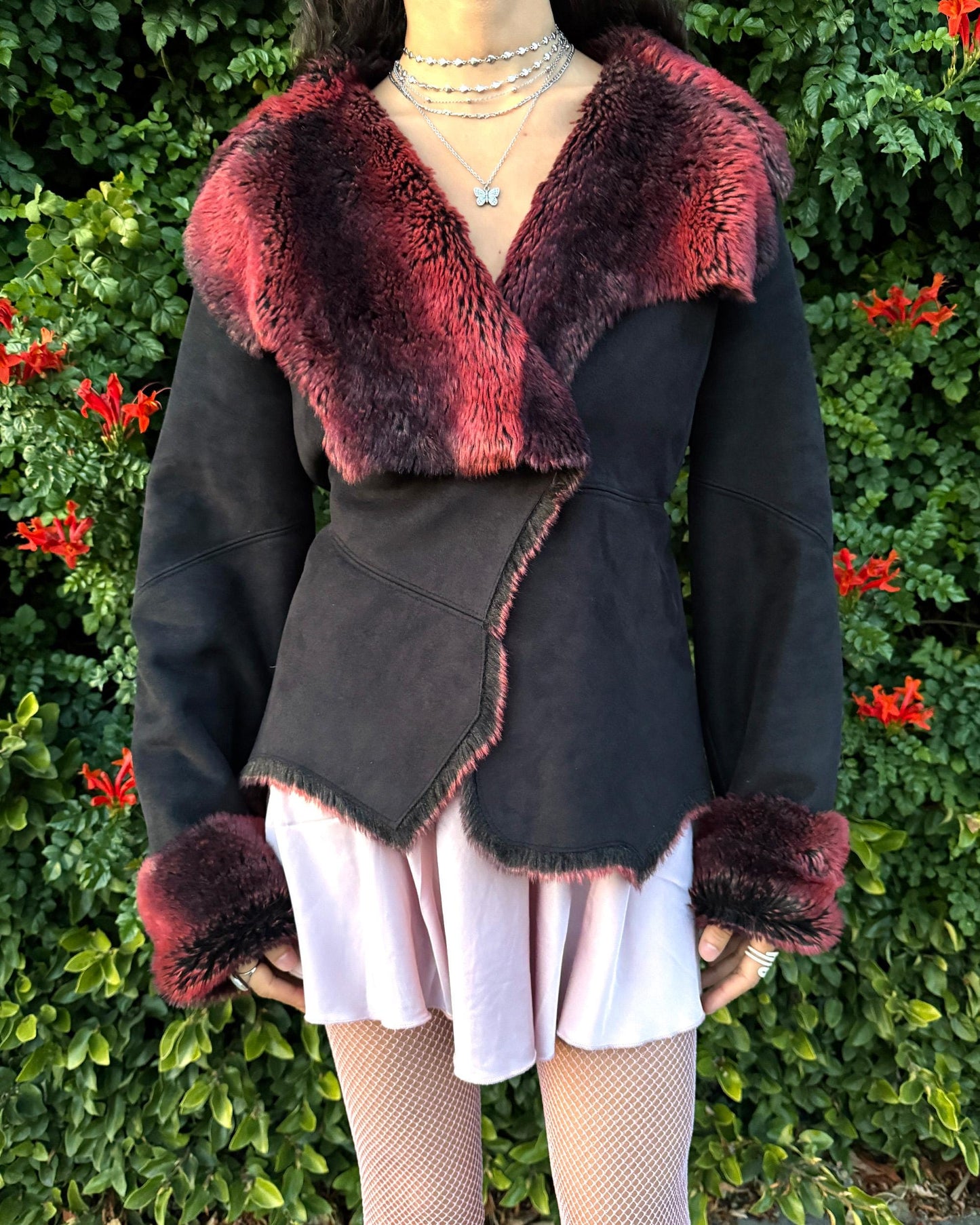 Stunning vintage 2000s Penny Lane–style jacket featuring a black faux-suede exterior with full red-and-black faux-fur lining. Designed with a dramatic faux-fur trimmed collar and cuffs, angled panel construction and a single button closure for a fitted silhouette. The polyester–acrylic blend has no stretch and provides a warm, cozy feel ideal for winter layering. A French-design cyber streetwear and grunge statement coat perfect for night outings and bold Y2K styling.