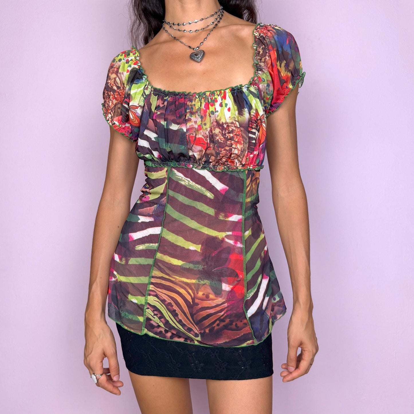 Vintage 2000s vibrant and colorful mesh top with a sheer abstract graphic print and a ruched bust. Features short puff sleeves, contrast seams, and a stretchy fitted silhouette that creates a bold statement look. Perfect for party nights, summer festivals, and weird-girl or cyber-inspired styling. Excellent vintage condition.