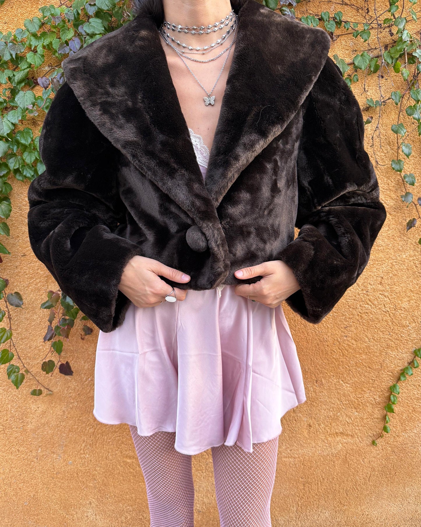 Vintage 90s dark brown faux fur cropped jacket featuring an exaggerated wide collar and a single hook-button closure. Soft, plush, and luxurious, it adds instant elegance to formal winter outfits and is perfect for gala events, prom nights, or refined evening layering. The cropped cut balances the dramatic collar, creating a chic silhouette that elevates dresses or slip styles with minimal effort. Made in Spain. Excellent vintage condition.