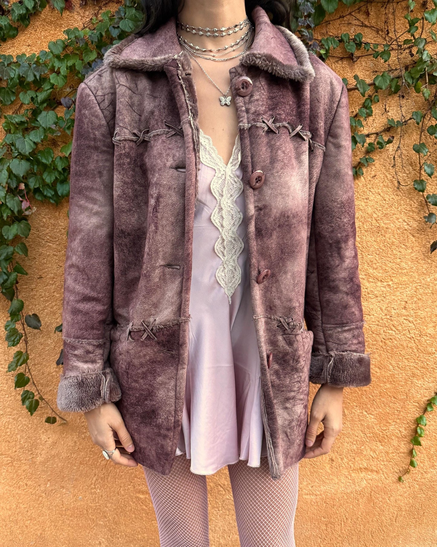 Vintage 2000s faux shearling coat in a rare reddish-brown (terracotta) tie-dye distressed finish. Features a faux fur collar and cuffs, button closure, side pockets, and decorative criss-cross stitch detailing for a dystopic cyber-grunge aesthetic. The straight silhouette makes it ideal for winter layering and festival styling. A standout 2000s piece for streetwear, weird-girl outfits, and bold cold-weather looks. Made from a polyester acrylic blend. Great vintage condition.