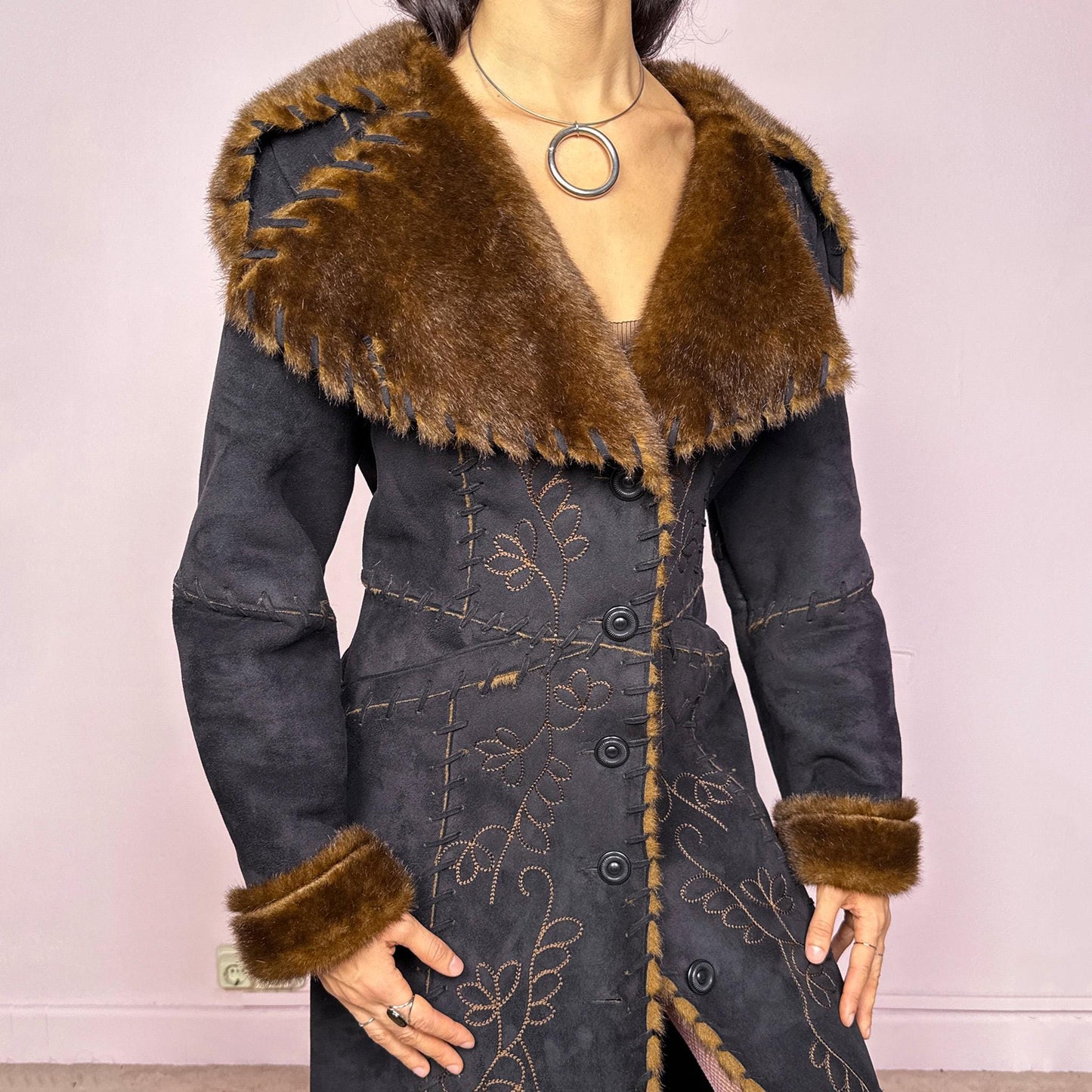 Stunning vintage 2000s dark gray almost black long Penny Lane coat with brown faux fur interior, collar, and cuffs. Features intricate floral embroidery, pockets, and button front closure. Soft faux suede with a warm feel, ideal for whimsical fairycore, boho, forest muse, and 70s Afghan-inspired Y2K styling. French-designed piece. Made from polyester. Excellent vintage condition.