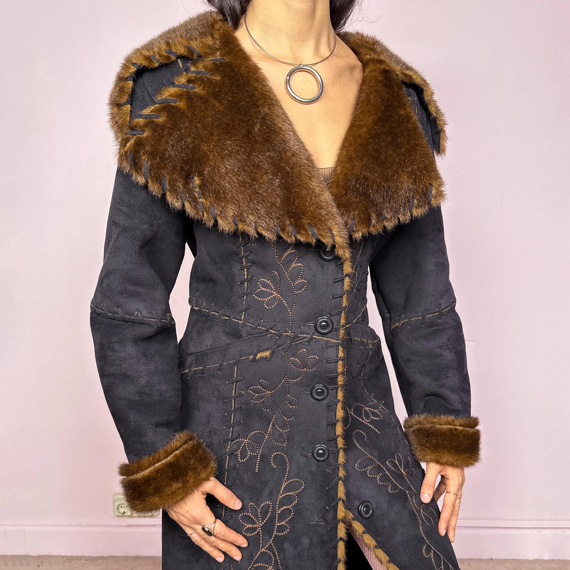 Stunning vintage 2000s dark gray almost black long Penny Lane coat with brown faux fur interior, collar, and cuffs. Features intricate floral embroidery, pockets, and button front closure. Soft faux suede with a warm feel, ideal for whimsical fairycore, boho, forest muse, and 70s Afghan-inspired Y2K styling. French-designed piece. Made from polyester. Excellent vintage condition.