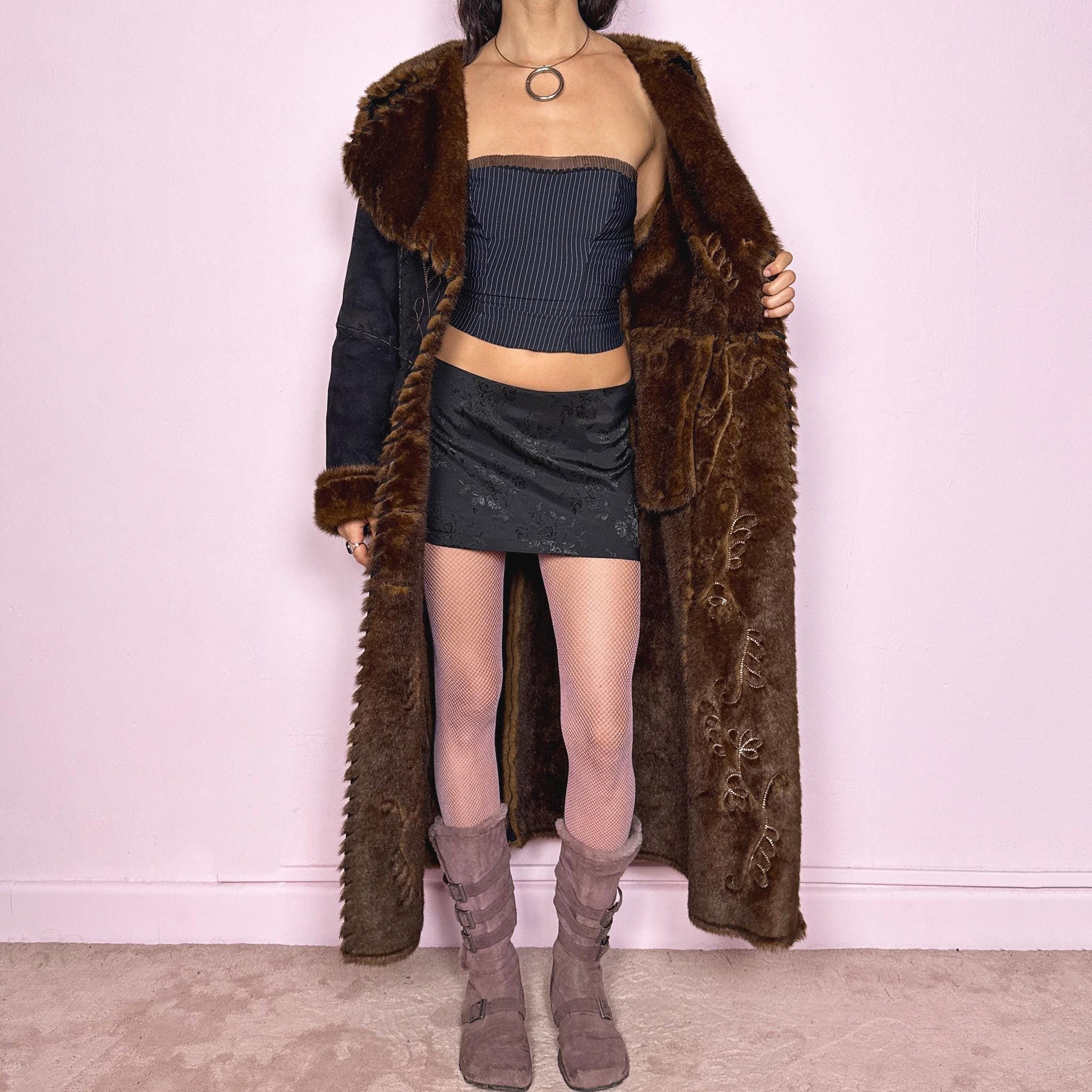 Stunning vintage 2000s dark gray almost black long Penny Lane coat with brown faux fur interior, collar, and cuffs. Features intricate floral embroidery, pockets, and button front closure. Soft faux suede with a warm feel, ideal for whimsical fairycore, boho, forest muse, and 70s Afghan-inspired Y2K styling. French-designed piece. Made from polyester. Excellent vintage condition.