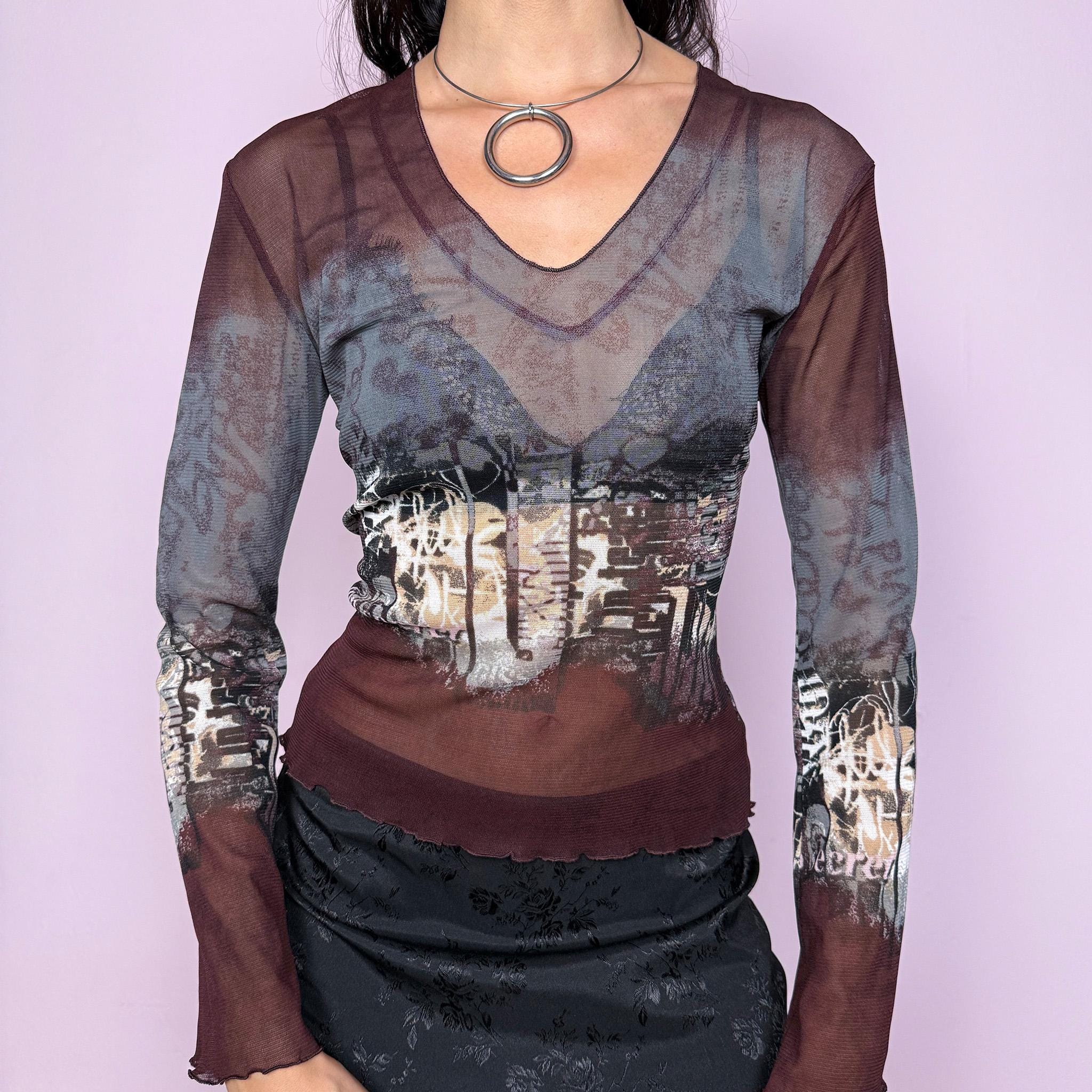 Vintage 2000s semi-sheer mesh top in gray and burgundy tones with an abstract city-inspired graphic print. Features a V neckline, long flared sleeves, and a stretchy fit. The deconstructed aesthetic give it a distinct cyber grunge and weird girl edge. Perfect for a casual yet statement everyday look. Excellent vintage condition.