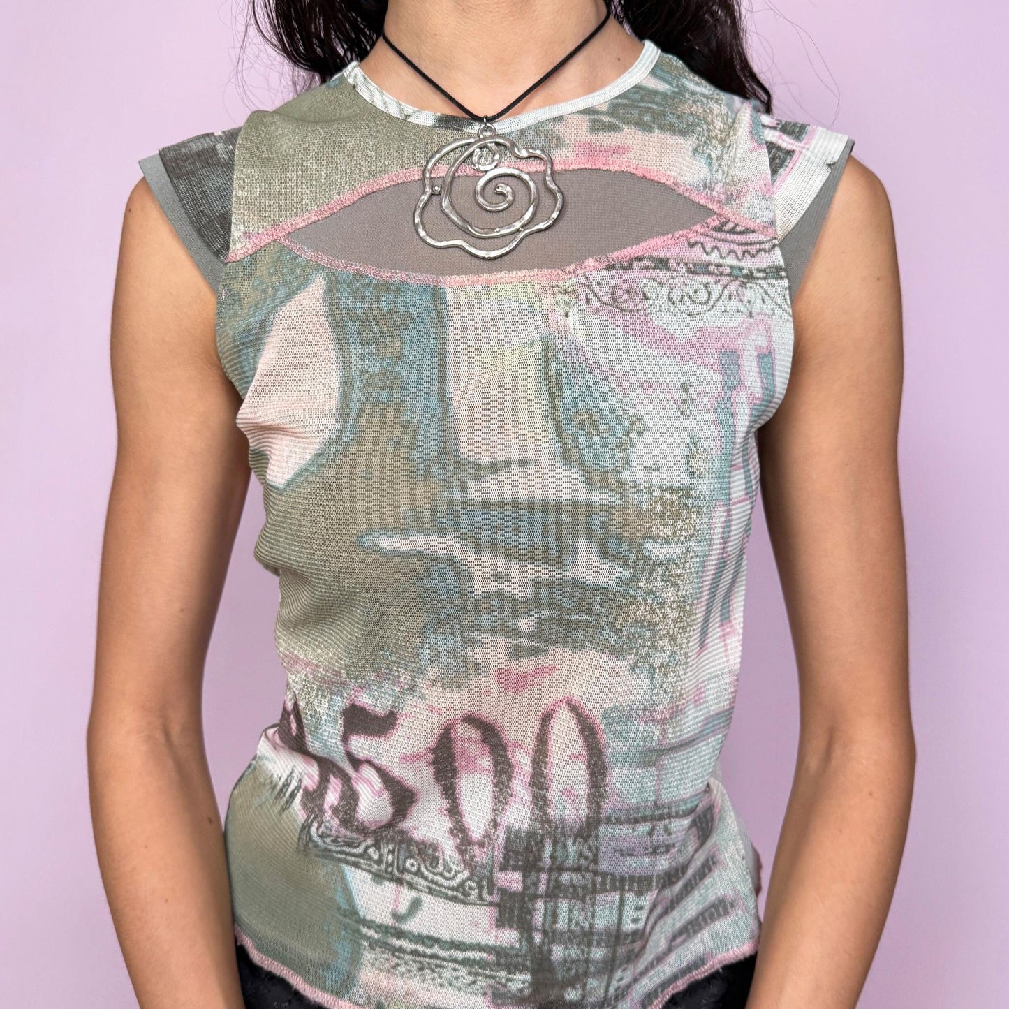 Vintage 2000s sleeveless mesh top in pastel light green and pink with an abstract money-inspired print. Features a crew neckline, cap sleeves, and a body-hugging stretchy fit with visible stitching for a deconstructed cyber grunge look. Lightweight and semi-sheer, perfect for summer parties, festivals, or casual layering. The weird girl aesthetic meets early 2000s street style in this unique statement piece. Great vintage condition.