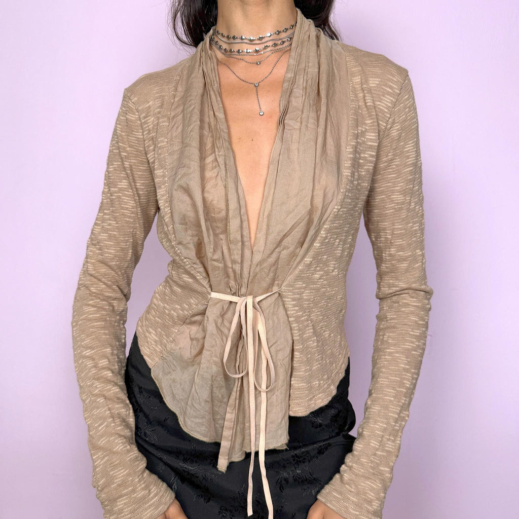 Vintage 2000s beige tie-front top with a deconstructed draped neckline that can be styled folded or loose. Features long sleeves and a stretchy textured fabric that creates an elegant, sculptural silhouette. Perfect for minimalist, office, or formal looks, yet versatile enough for casual layering. This understated piece blends sophistication with modern avant-garde simplicity. Excellent vintage condition.