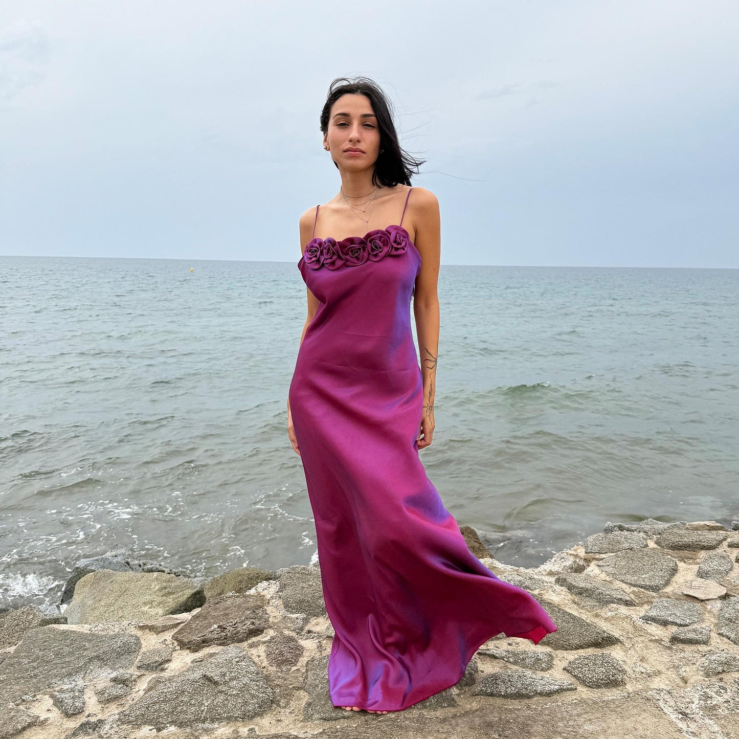 Vintage Y2K iridescent slip midi dress from the 2000s in a stunning maroon tone with blueish undertones that shift toward purple depending on light reflection. Features a sculptural rosette appliqué along the bust and spaghetti straps. The shimmering surface enhances its red carpet appeal, making it ideal for proms, summer weddings, gala events, or romantic evenings. Made in France from a non-stretch polyester viscose blend fabric. Great vintage condition.