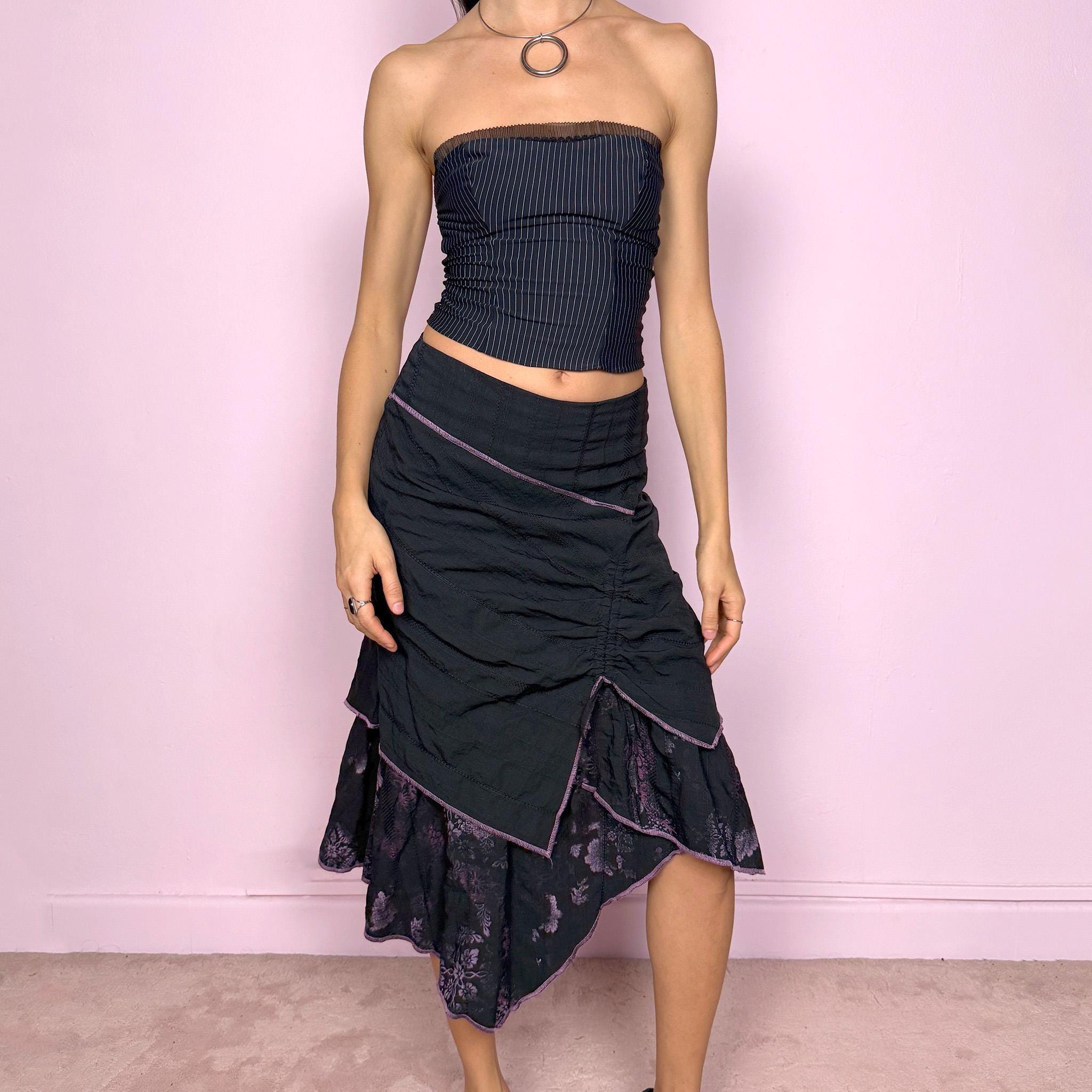 Vintage 2000s black midi skirt with deconstructed avant-garde design, featuring ruched tie drawstring front, layered construction, and ruffle hem. Structured no-stretch fit with back zip closure, ideal for witchy grunge, cyber futuristic layering, or statement event styling. Can be worn mid to low rise for XXS/XS or high waisted for S. Made in France by a Paris-based brand from a cotton polyester blend. Great vintage condition.
