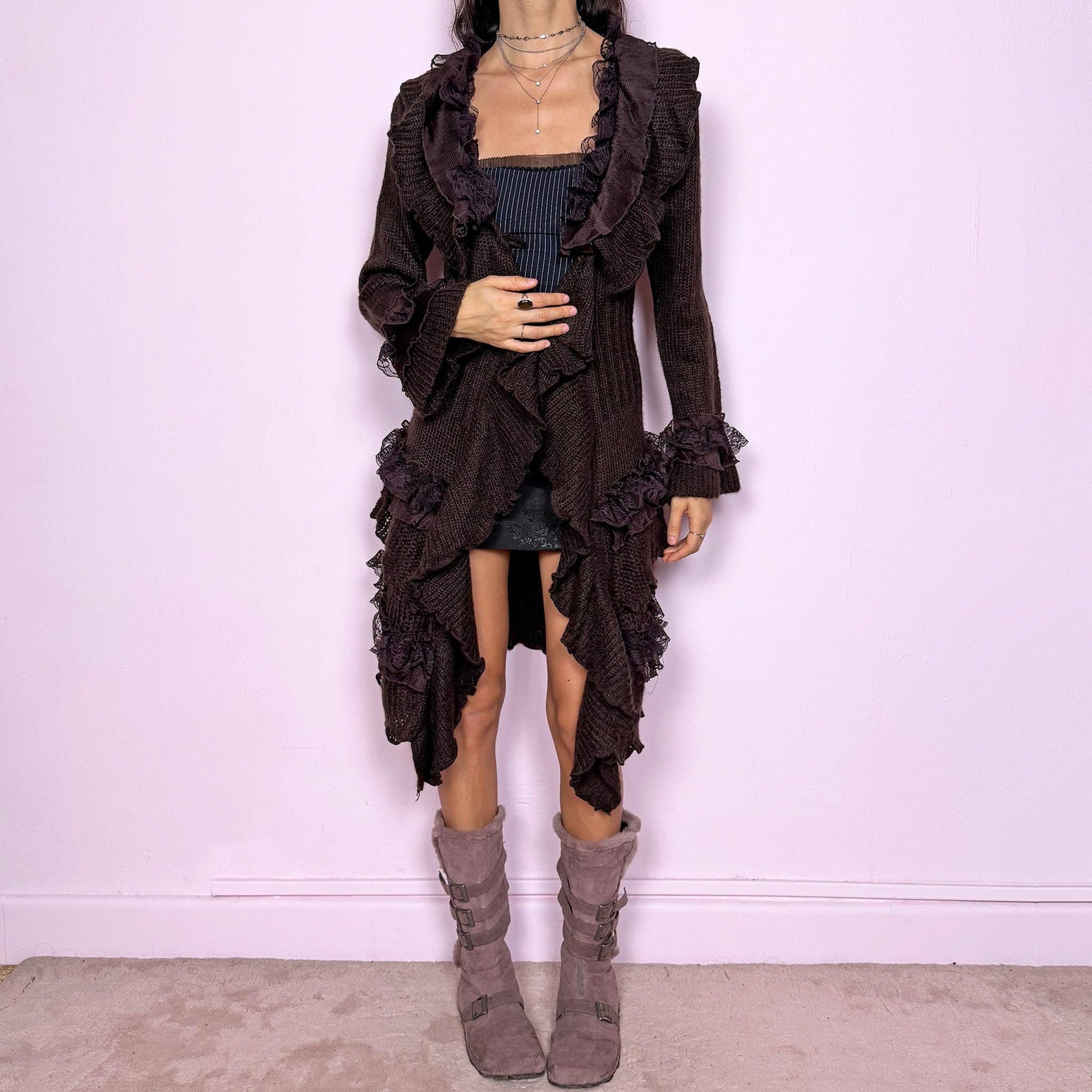 Romantic vintage 2000s dark brown longline cardigan with dramatic ruffle neckline and lace details. Features bell sleeves with ruffle cuffs, toggle front closure, and asymmetric pointy hem. Whimsical fairycore silhouette with dark baroque rococo style. Stretchy fabric for cozy winter layering. Made from acrylic mohair wool blend. Excellent vintage condition.
