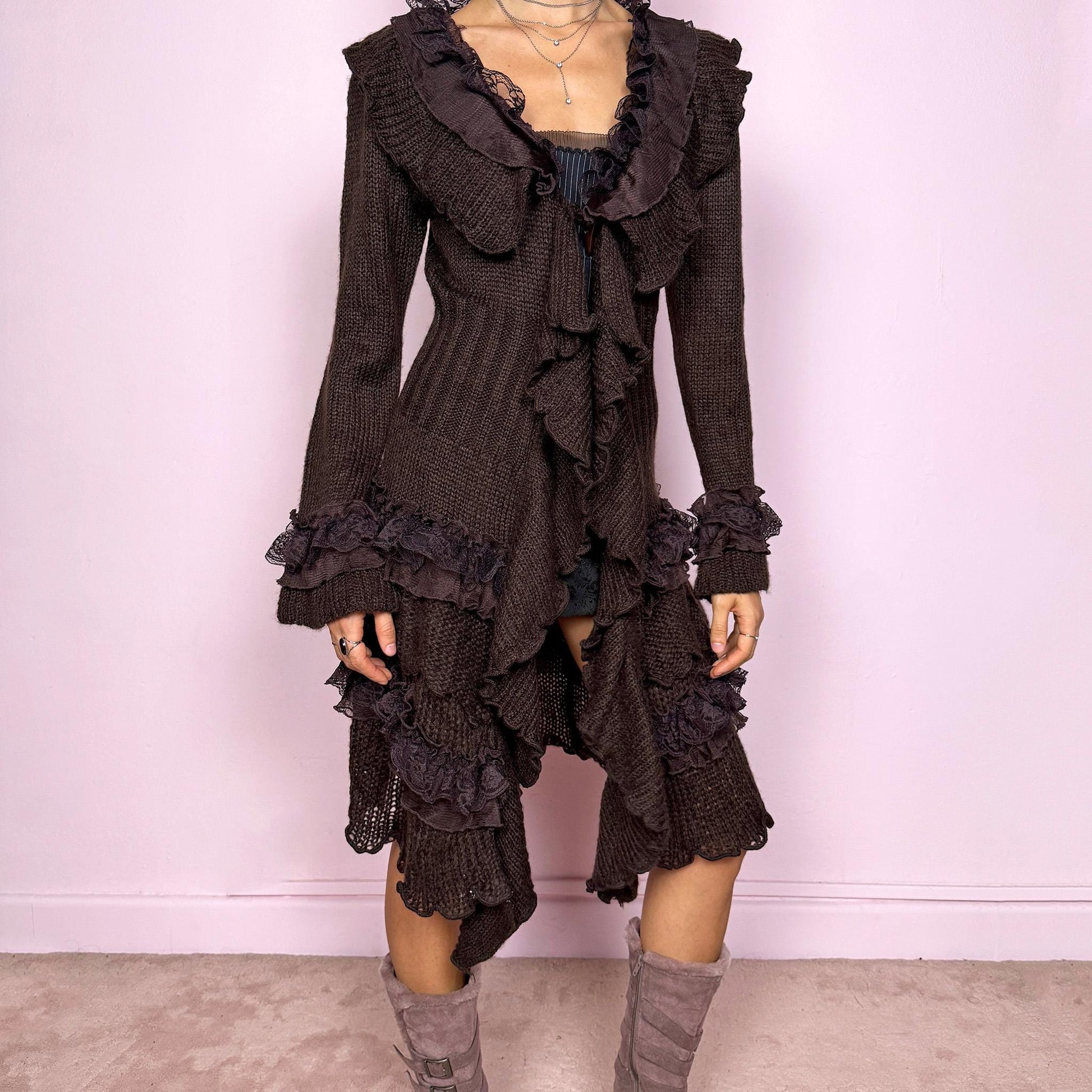 Romantic vintage 2000s dark brown longline cardigan with dramatic ruffle neckline and lace details. Features bell sleeves with ruffle cuffs, toggle front closure, and asymmetric pointy hem. Whimsical fairycore silhouette with dark baroque rococo style. Stretchy fabric for cozy winter layering. Made from acrylic mohair wool blend. Excellent vintage condition.