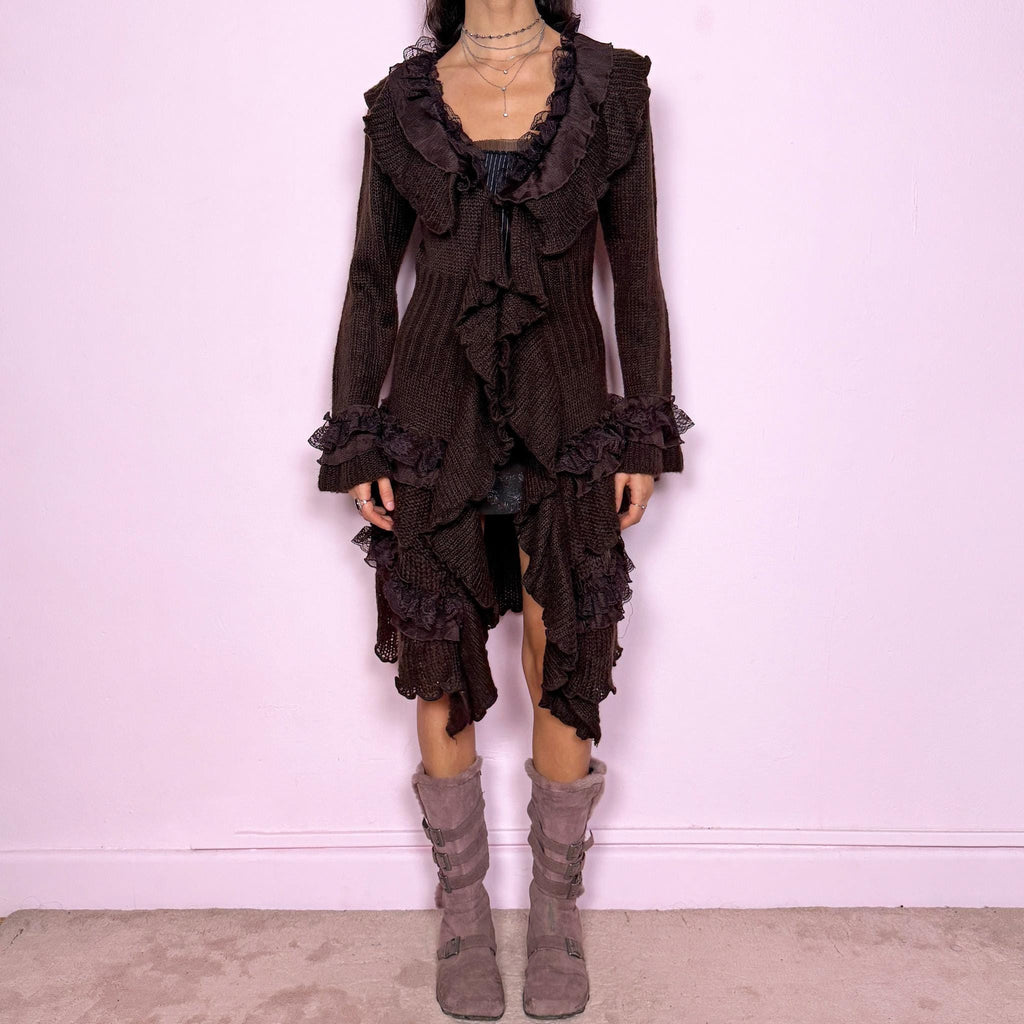 Romantic vintage 2000s dark brown longline cardigan with dramatic ruffle neckline and lace details. Features bell sleeves with ruffle cuffs, toggle front closure, and asymmetric pointy hem. Whimsical fairycore silhouette with dark baroque rococo style. Stretchy fabric for cozy winter layering. Made from acrylic mohair wool blend. Excellent vintage condition.