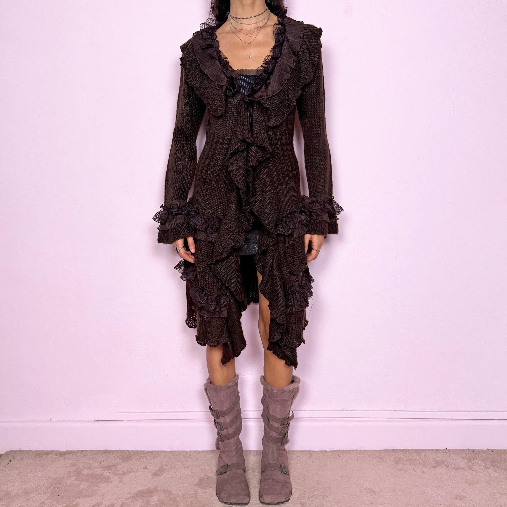 Romantic vintage 2000s dark brown longline cardigan with dramatic ruffle neckline and lace details. Features bell sleeves with ruffle cuffs, toggle front closure, and asymmetric pointy hem. Whimsical fairycore silhouette with dark baroque rococo style. Stretchy fabric for cozy winter layering. Made from acrylic mohair wool blend. Excellent vintage condition.