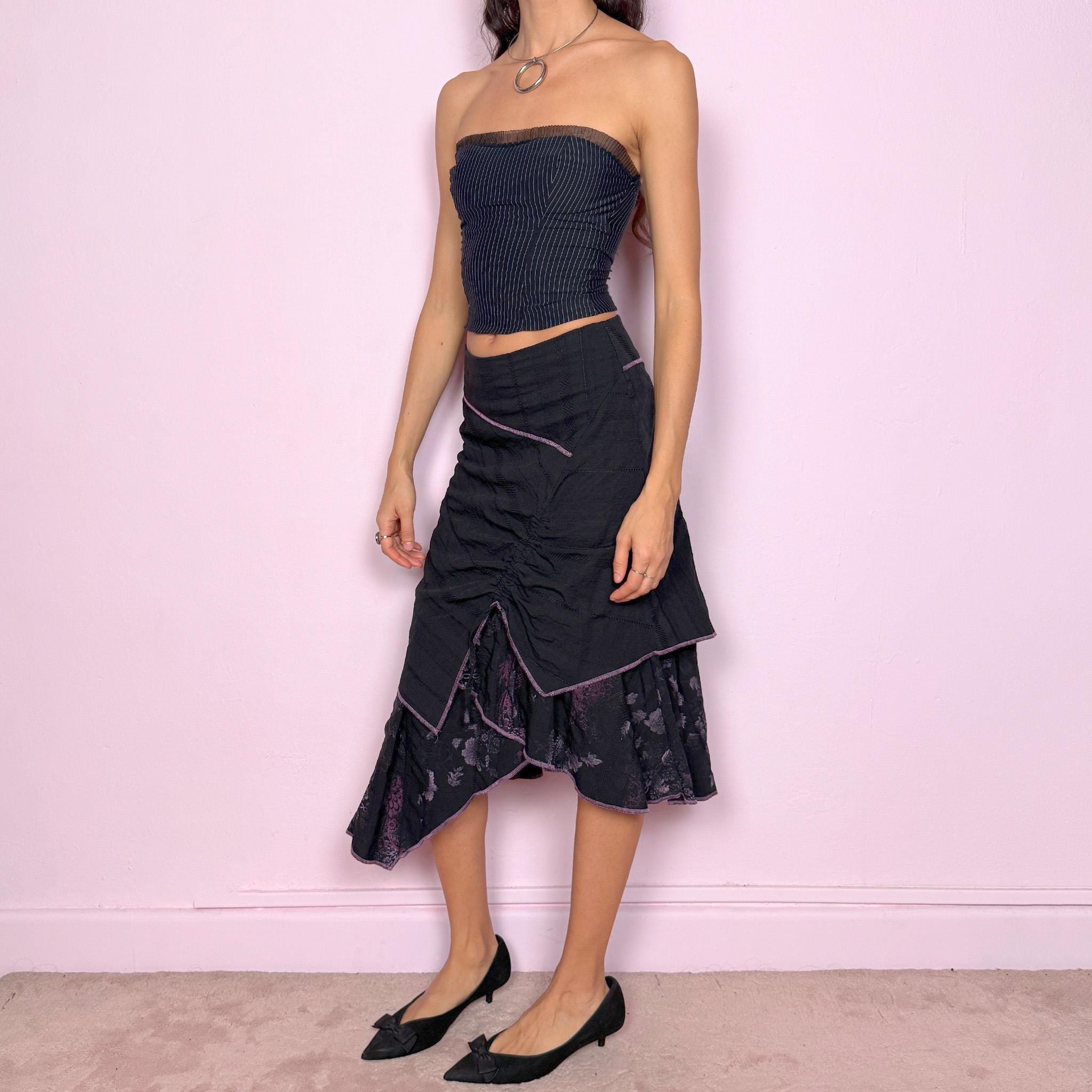 Vintage 2000s black midi skirt with deconstructed avant-garde design, featuring ruched tie drawstring front, layered construction, and ruffle hem. Structured no-stretch fit with back zip closure, ideal for witchy grunge, cyber futuristic layering, or statement event styling. Can be worn mid to low rise for XXS/XS or high waisted for S. Made in France by a Paris-based brand from a cotton polyester blend. Great vintage condition.