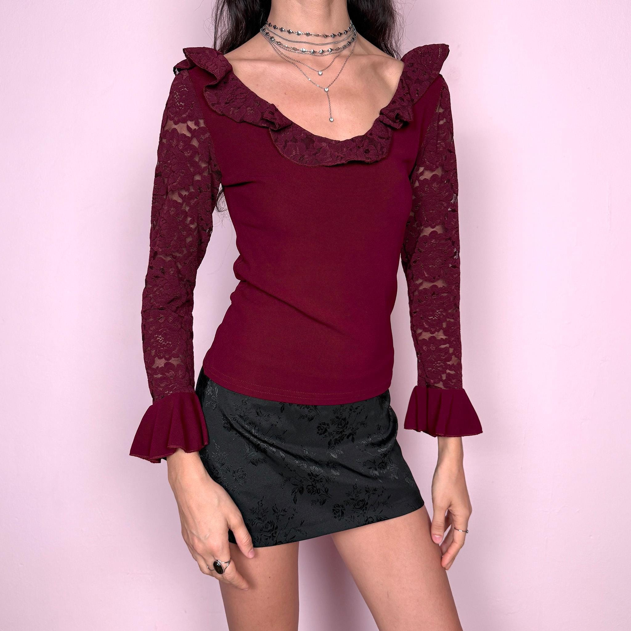 Romantic vintage 2000s burgundy maroon blouse with lace sleeves, ruffled cuffs, and a ruffle lace neckline. Stretchy viscose-nylon-polyamide blend creates a flattering, fitted silhouette. Perfect for coquette, Victorian-inspired evening looks or elegant night styling. Made by a French brand. Excellent vintage condition.