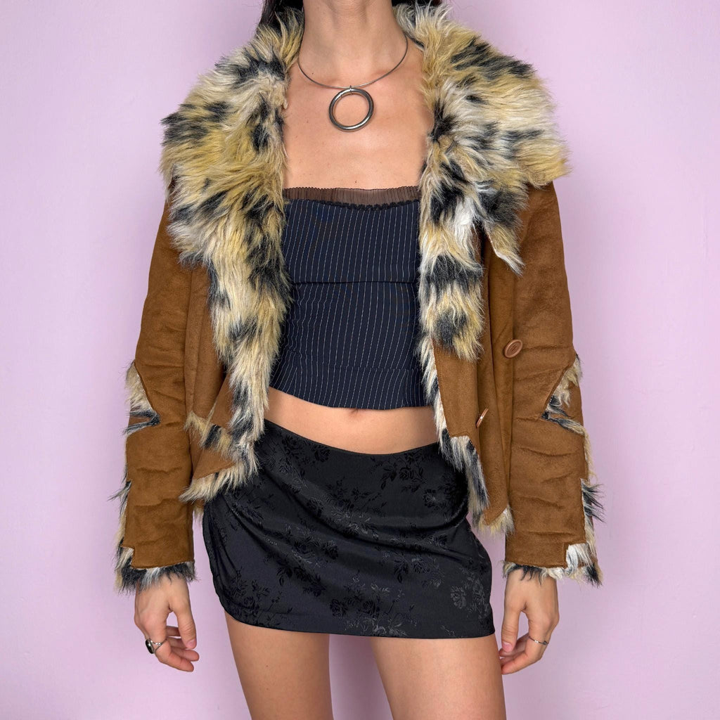 Bold statement vintage 2000s Penny Lane jacket with a brown faux suede exterior and beige and black faux fur interior and collar with an animal print–inspired look. Eye-catching unique design with a fitted silhouette, two-button closure, pockets, and an asymmetric hem. Made from polyester by a European brand. Excellent vintage condition.