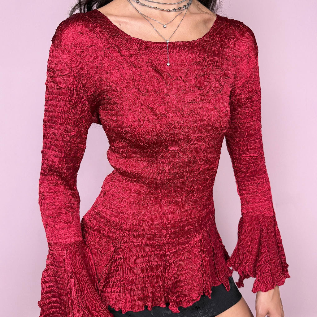 Stunning vintage 2000s burgundy maroon crinkle-pleated blouse featuring dramatic asymmetric bell sleeves, a fitted silhouette, and an asymmetric flared hem. Romantic and avant-garde, ideal for formal parties, festivals, or bold evening wear. Rare archival French design made from polyester by a French brand. Excellent vintage condition.