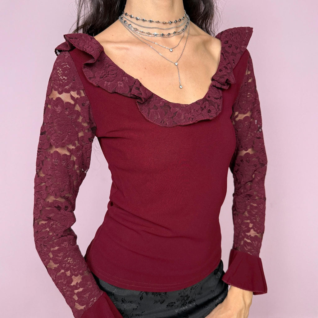 Romantic vintage 2000s burgundy maroon blouse with lace sleeves, ruffled cuffs, and a ruffle lace neckline. Stretchy viscose-nylon-polyamide blend creates a flattering, fitted silhouette. Perfect for coquette, Victorian-inspired evening looks or elegant night styling. Made by a French brand. Excellent vintage condition.