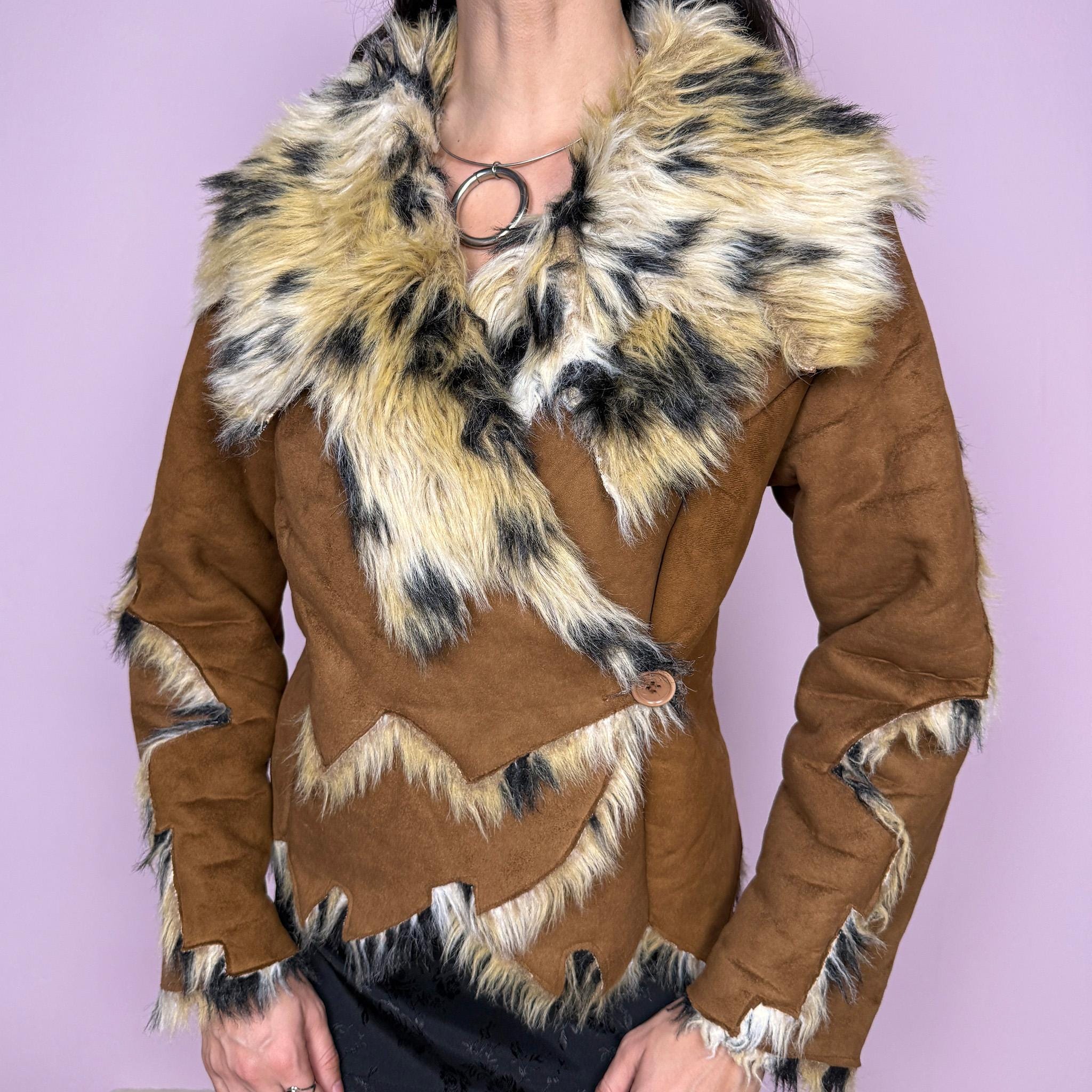 Bold statement vintage 2000s Penny Lane jacket with a brown faux suede exterior and beige and black faux fur interior and collar with an animal print–inspired look. Eye-catching unique design with a fitted silhouette, two-button closure, pockets, and an asymmetric hem. Made from polyester by a European brand. Excellent vintage condition.