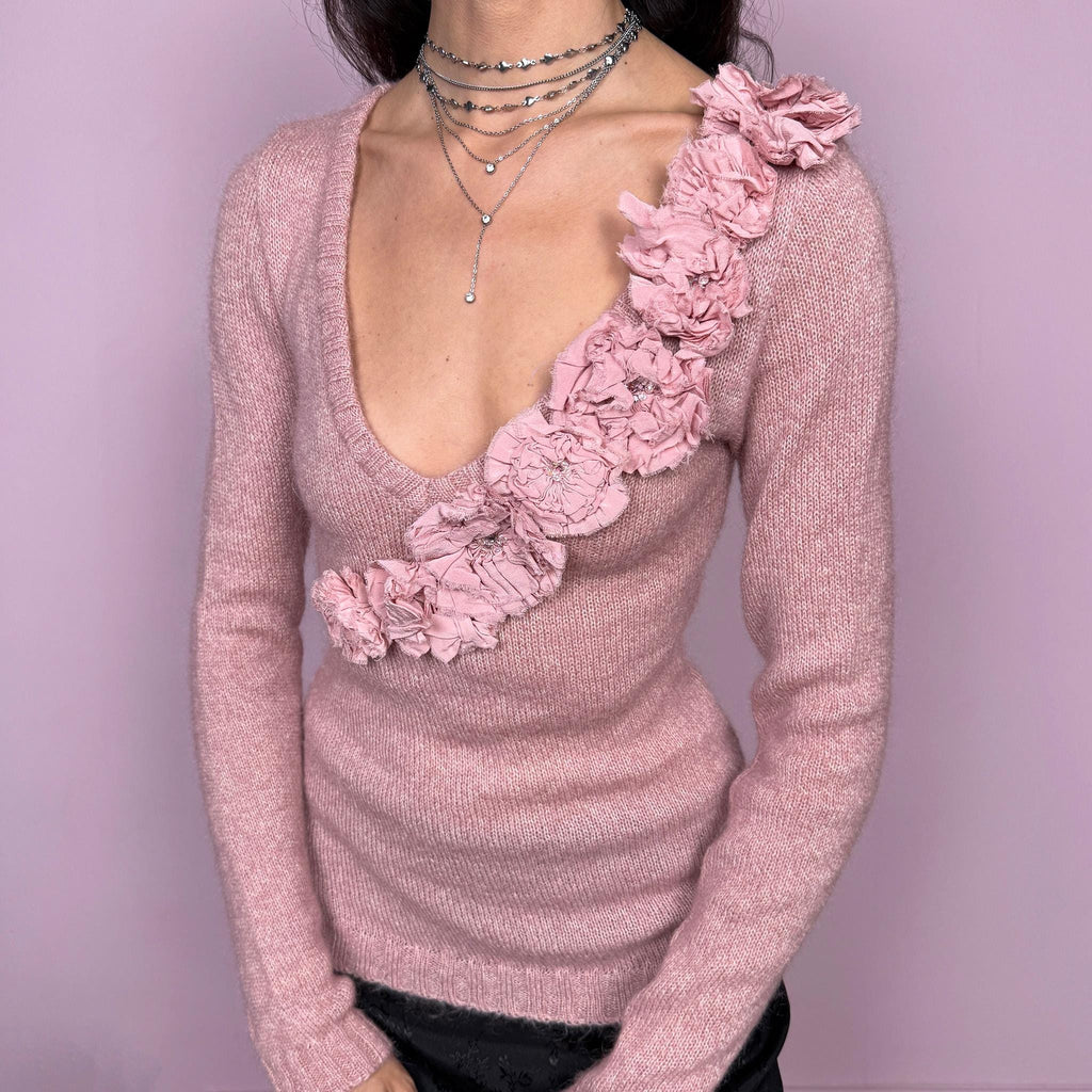 Vintage early 2000s romantic feminine sweater by Moschino Cheap and Chic, Italian designer. Deep V-neck with long sleeves and a fitted silhouette. Features a dramatic cascading rosette appliqué across the front, creating a striking, unique avant-garde statement. Perfect for coquette or balletcore-inspired winter styling. Made in Italy from 100% virgin wool. Excellent vintage condition.