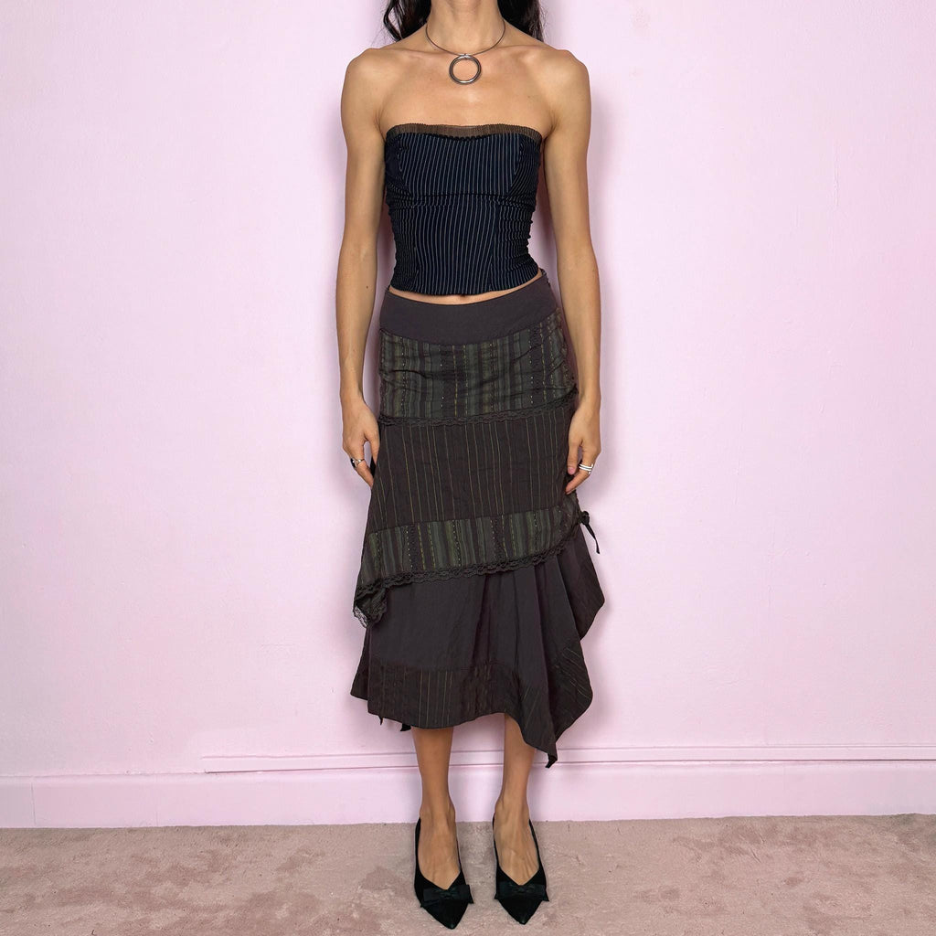 Vintage 2000s dark brown asymmetric midi skirt with an avant garde deconstructed layered design, featuring striped panels with subtle green lines, lace trim, and tie drawstring side details. Side zipper closure with no stretch. Fairy grunge aesthetic. Can be worn high waisted for size S or worn lower on the waist for size XS/XXS. Made by a French brand from a cotton polyester polyamide blend. Great vintage condition.