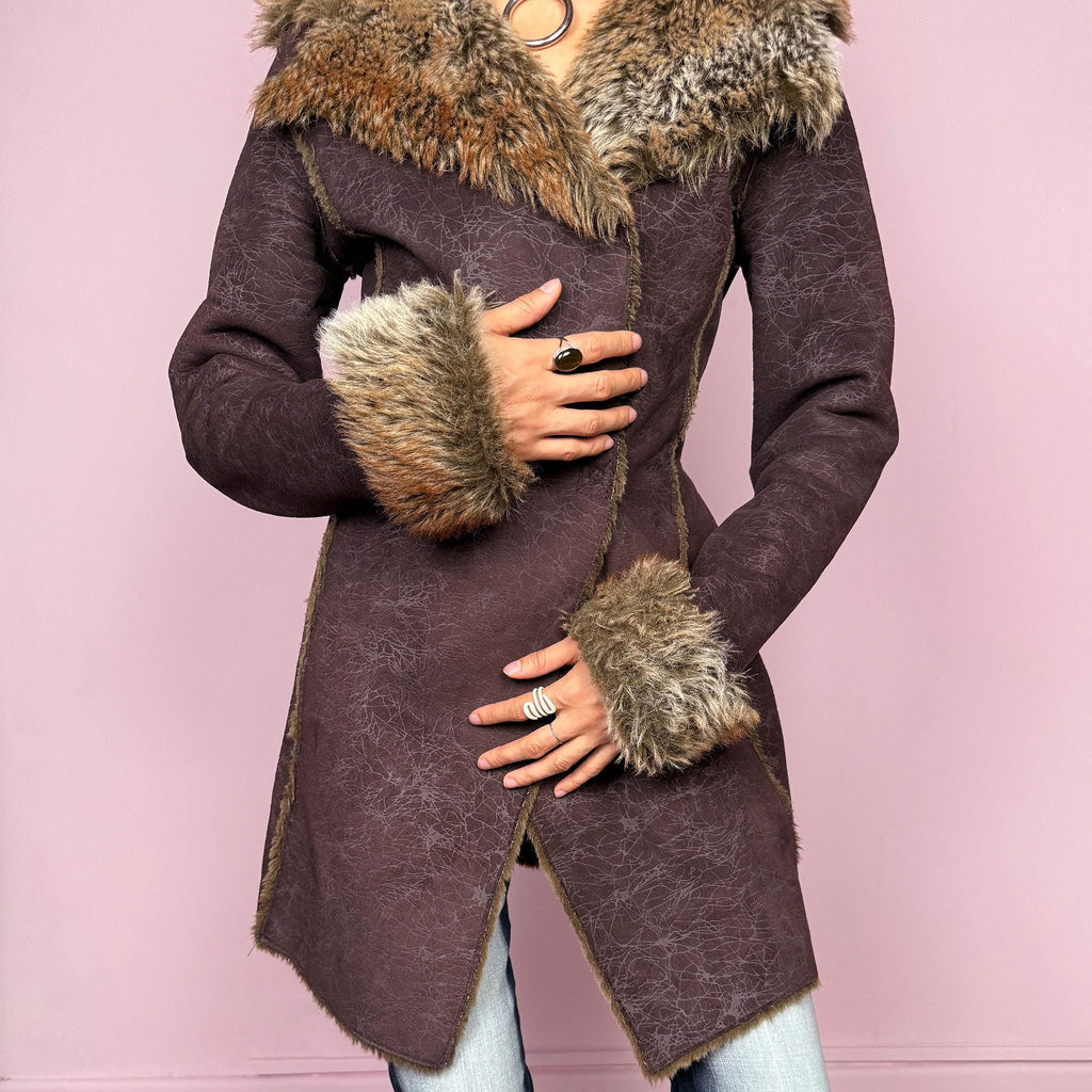 Vintage 2000s brown long coat in a statement penny lane style with a fitted silhouette. Features snap button closure, matching fabric belt, and plush brown and beige faux fur lining at the collar and cuffs. Perfect for city girl winter and Y2K styling. Made from a polyester acrylic blend. Excellent vintage condition.