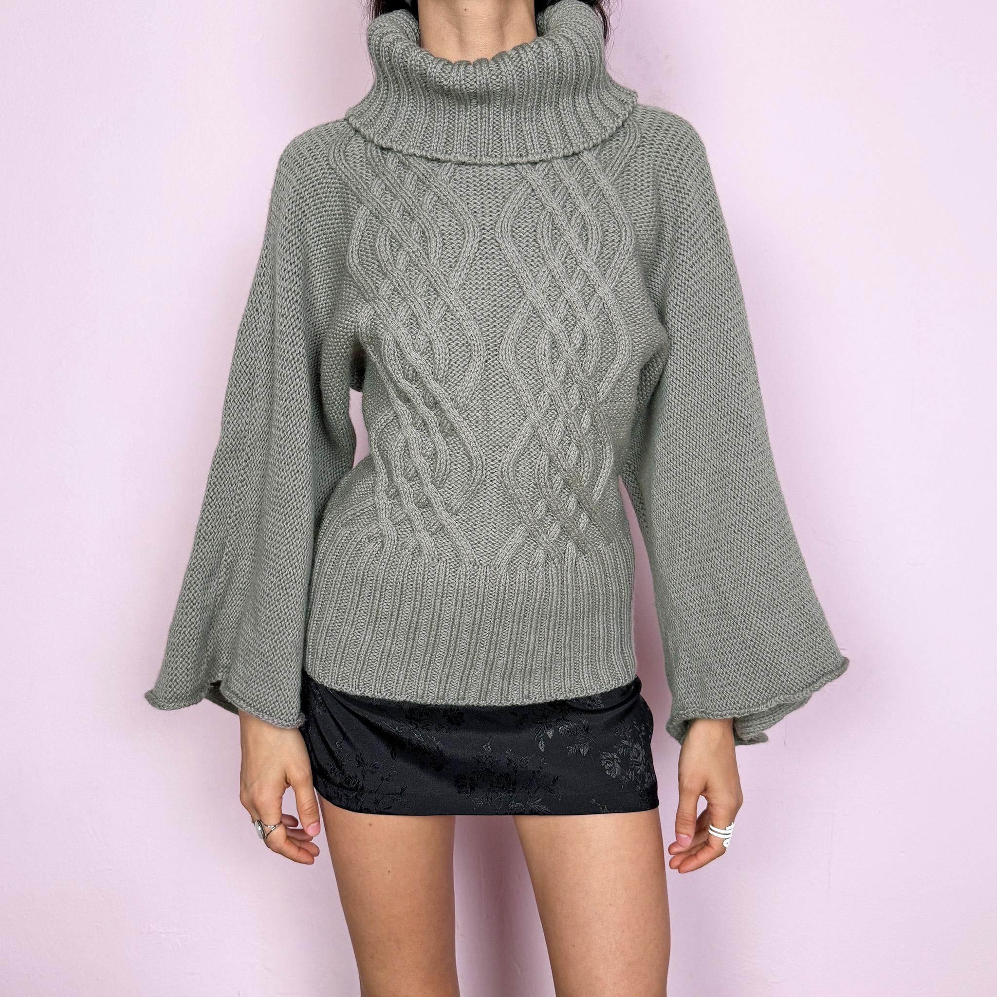 Vintage khaki green grayish 100% pure new wool cable knit sweater featuring a chunky texture, an oversized turtleneck, and wide long sleeves. Crafted from thick, high-quality wool for warmth and a refined feel, making it a standout staple for colder seasons. Made in England. Excellent vintage condition.