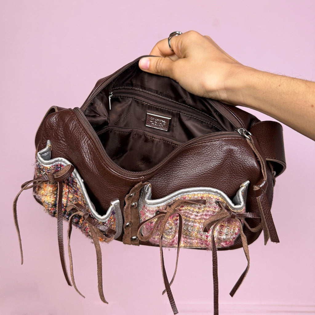 Vintage 2000s genuine leather shoulder bag made in Italy by Cromia, crafted in rich brown leather with textured woven panel details, delicate tie ribbon accents, and studded details. Features a structured baguette silhouette with zip closure and artisanal finishes, blending boho romantic and fairycore aesthetics. Great vintage condition.