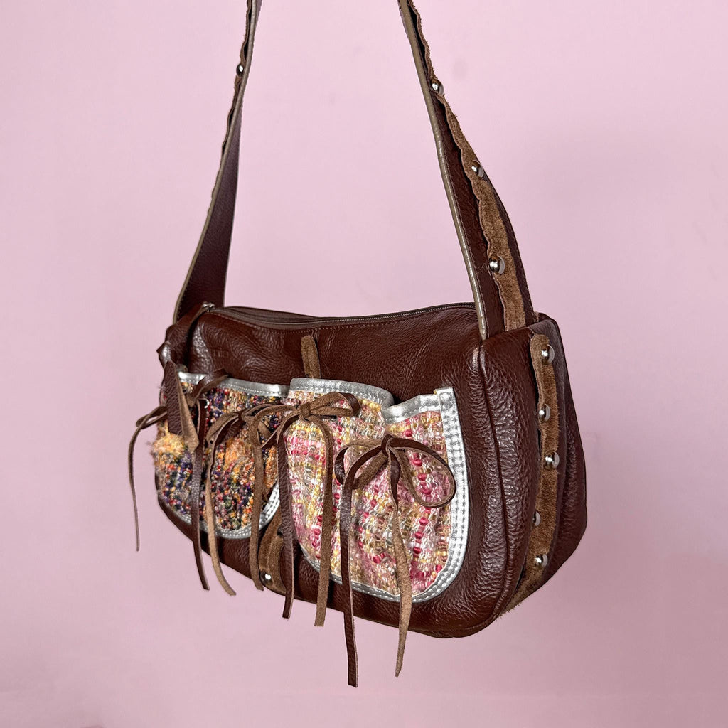 Vintage 2000s genuine leather shoulder bag made in Italy by Cromia, crafted in rich brown leather with textured woven panel details, delicate tie ribbon accents, and studded details. Features a structured baguette silhouette with zip closure and artisanal finishes, blending boho romantic and fairycore aesthetics. Great vintage condition.