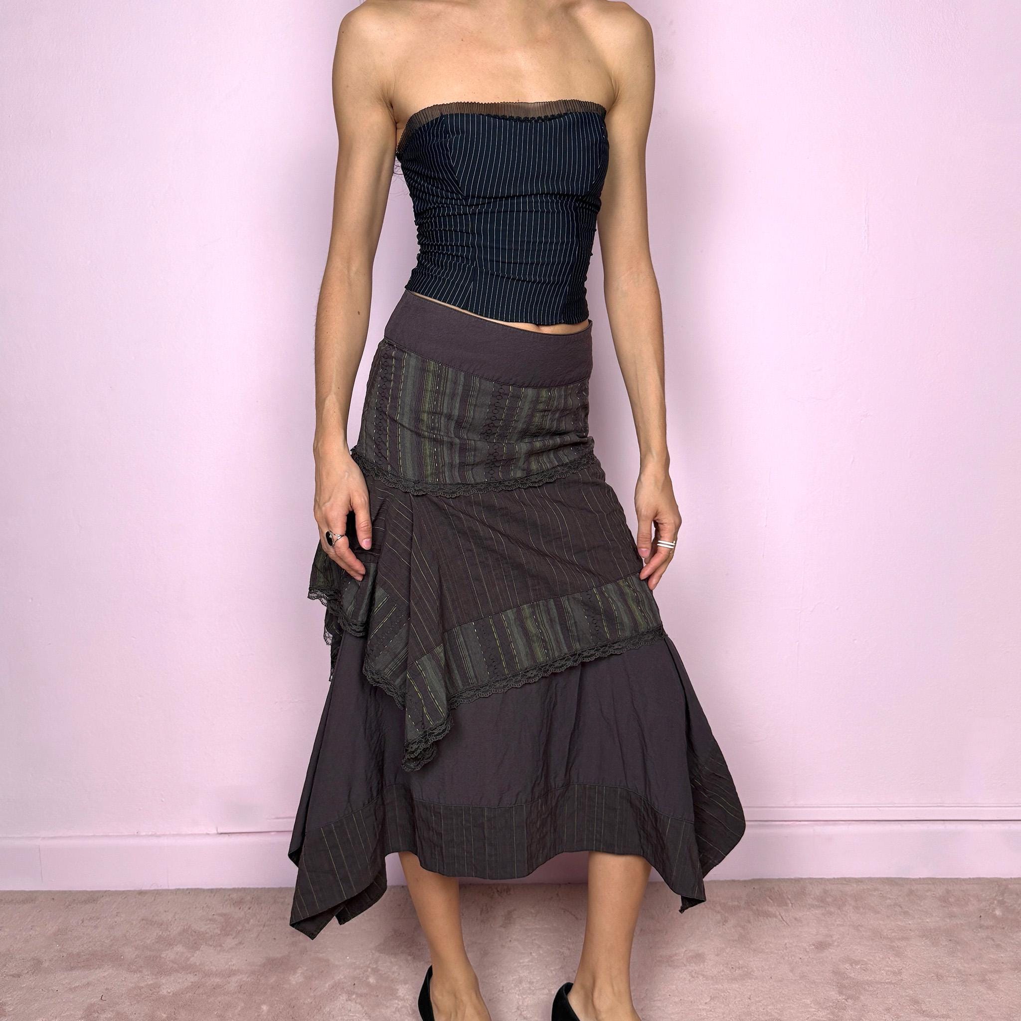 Vintage 2000s dark brown asymmetric midi skirt with an avant garde deconstructed layered design, featuring striped panels with subtle green lines, lace trim, and tie drawstring side details. Side zipper closure with no stretch. Fairy grunge aesthetic. Can be worn high waisted for size S or worn lower on the waist for size XS/XXS. Made by a French brand from a cotton polyester polyamide blend. Great vintage condition.