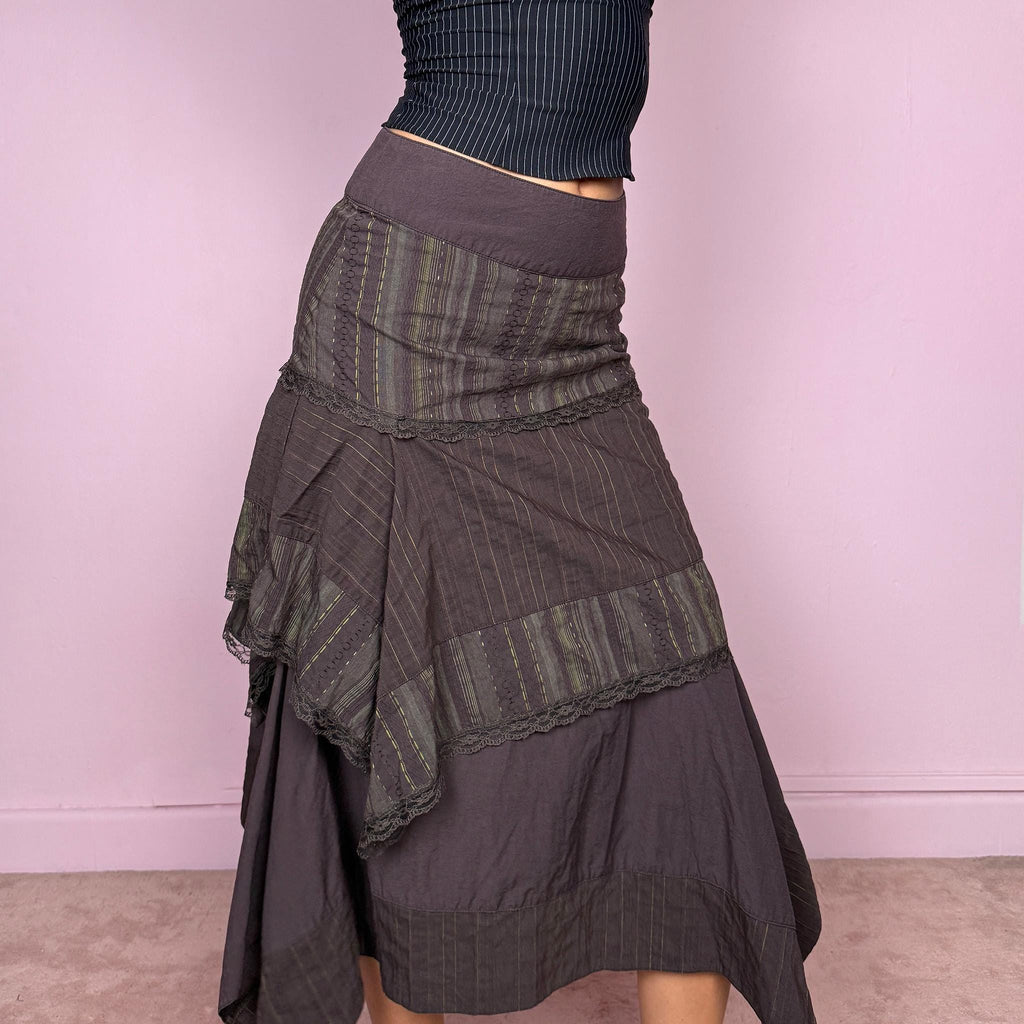 Vintage 2000s dark brown asymmetric midi skirt with an avant garde deconstructed layered design, featuring striped panels with subtle green lines, lace trim, and tie drawstring side details. Side zipper closure with no stretch. Fairy grunge aesthetic. Can be worn high waisted for size S or worn lower on the waist for size XS/XXS. Made by a French brand from a cotton polyester polyamide blend. Great vintage condition.